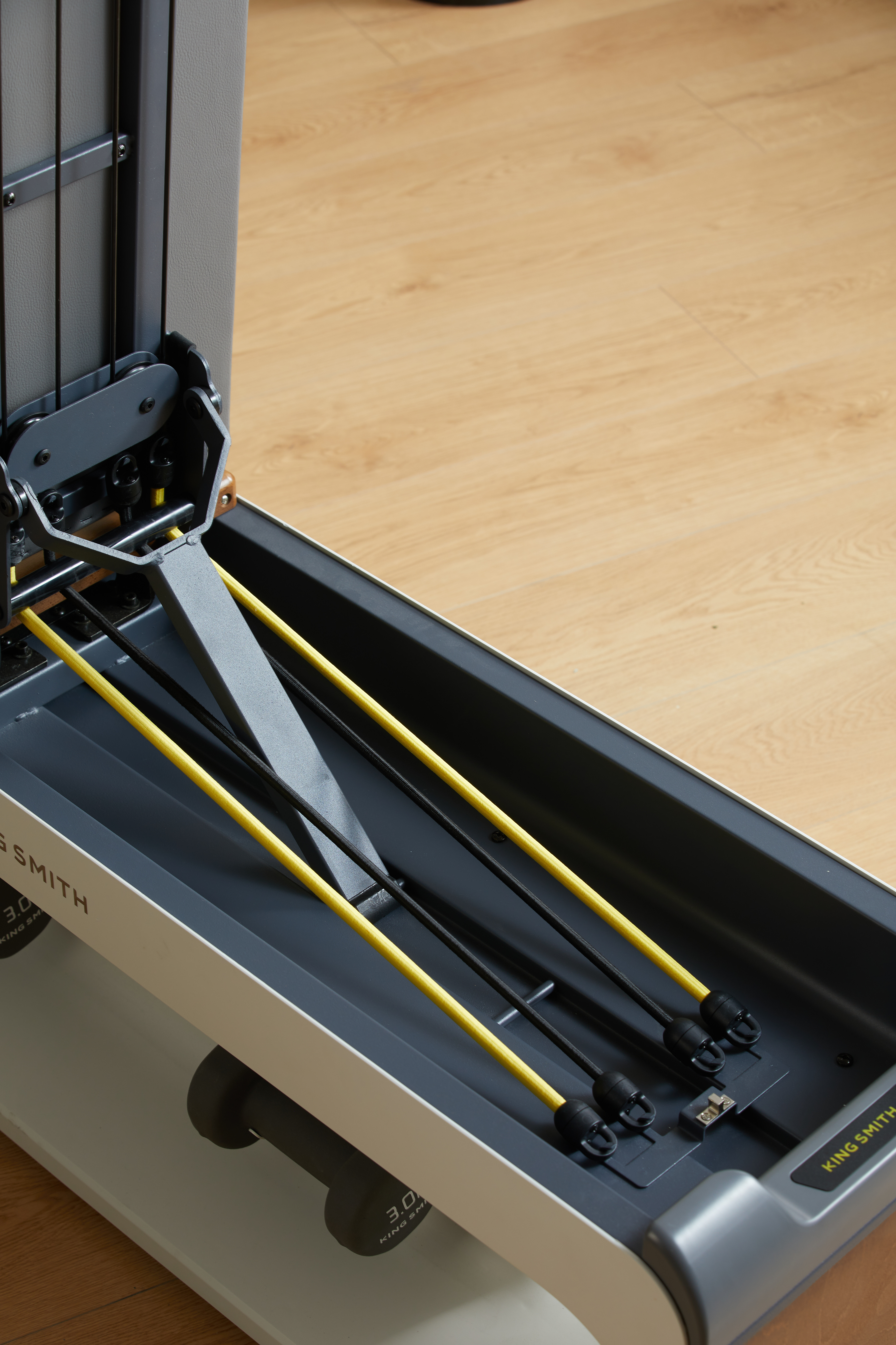 Maszyna do ćwiczeń z ciężarami z żółtymi i czarnymi taśmami do ćwiczeń i hantlem.