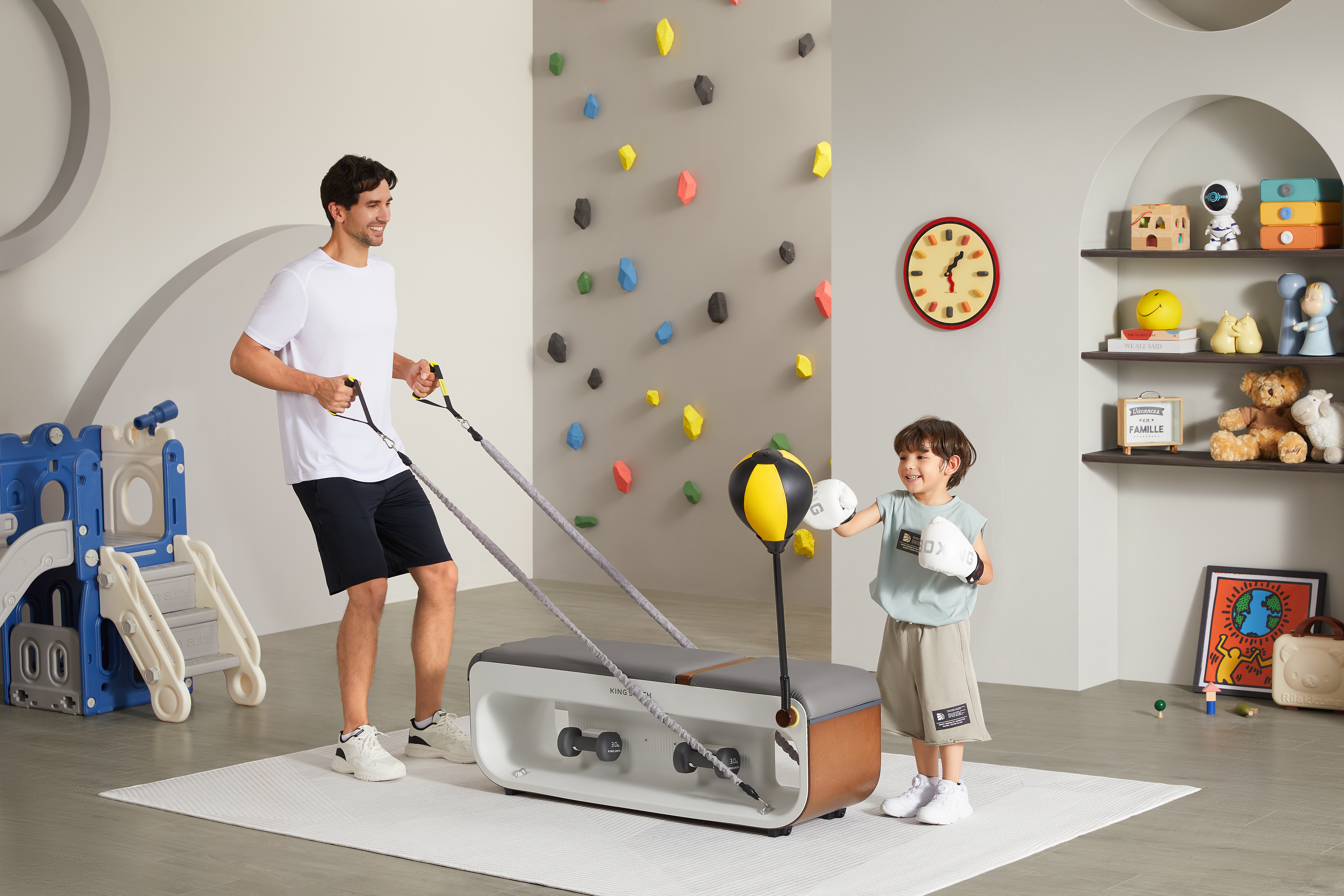 Mężczyzna i chłopiec ćwiczą w pokoju. Używają ławki z ciężarami i worka bokserskiego.