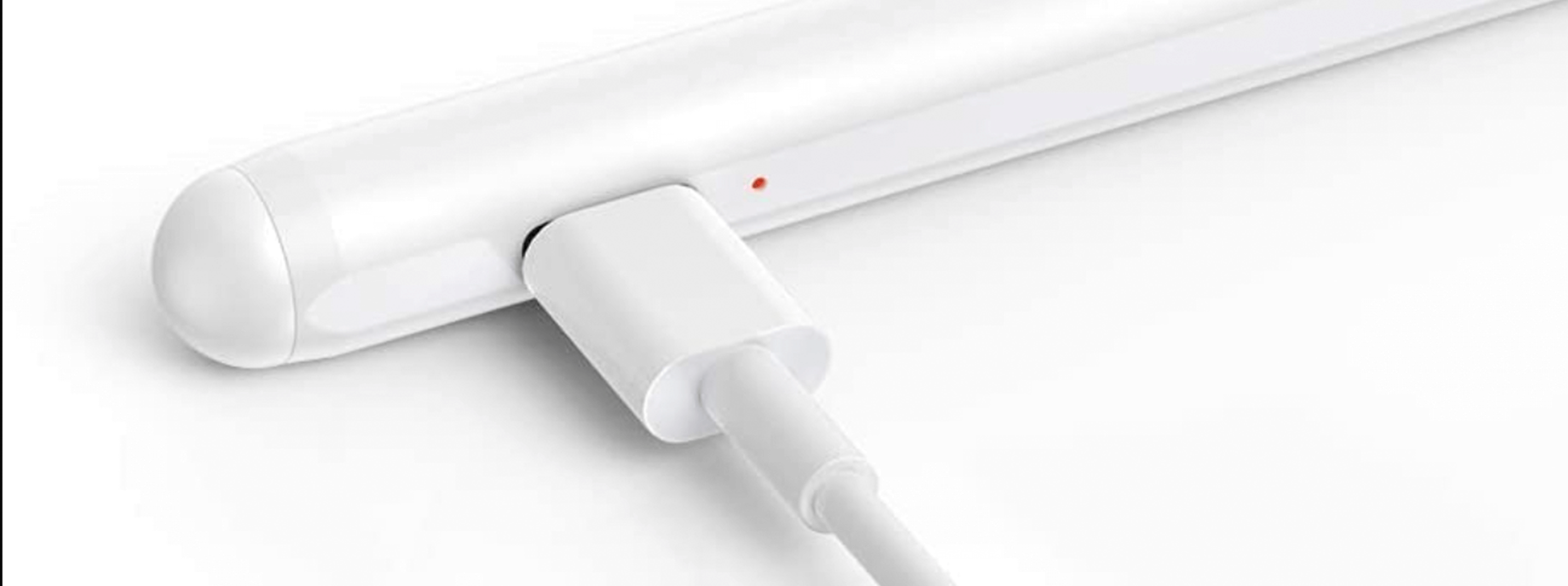 Biały długopis z włożonym kablem ładującym na białym tle.