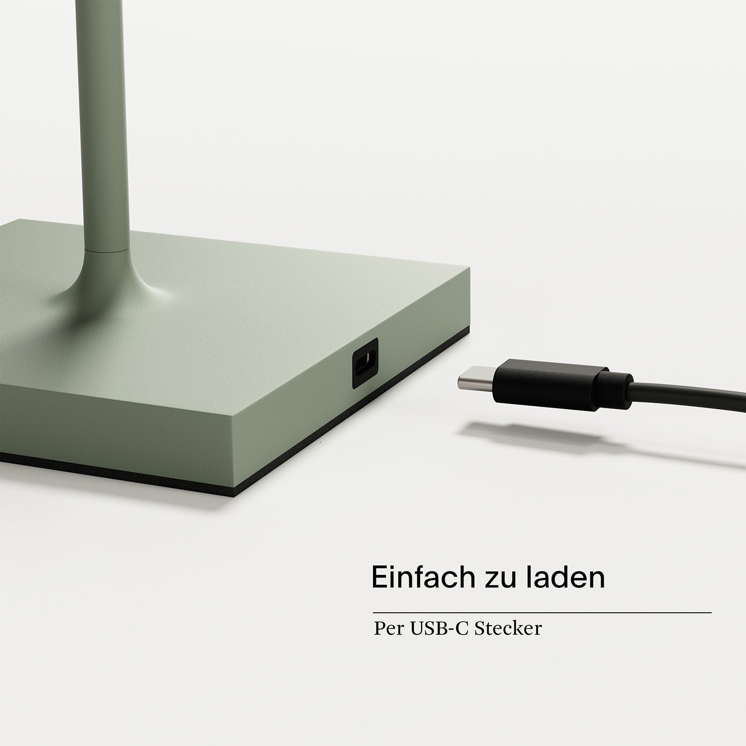Grüner Lampensockel mit Stromeingang und schwarzem Ladekabel.