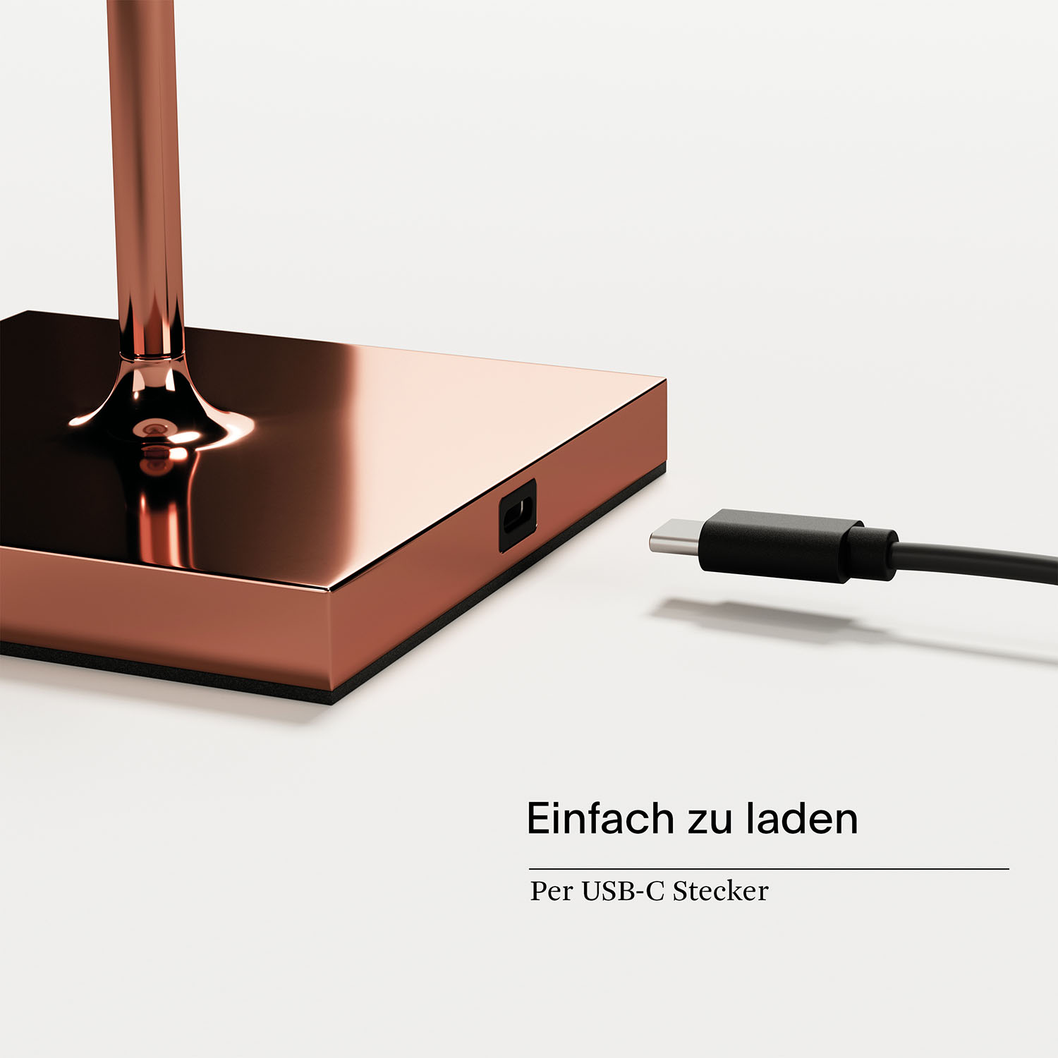 Nahaufnahme eines Ladeanschlusses auf kupferfarbener Basis mit Kabel.