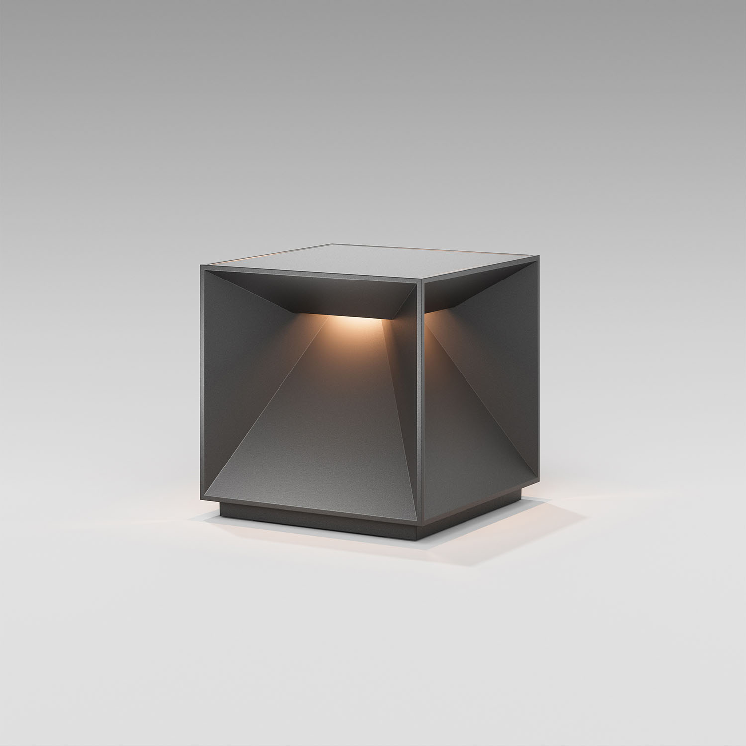 Eine dunkelgraue würfelförmige Lampe, aus der Licht scheint.