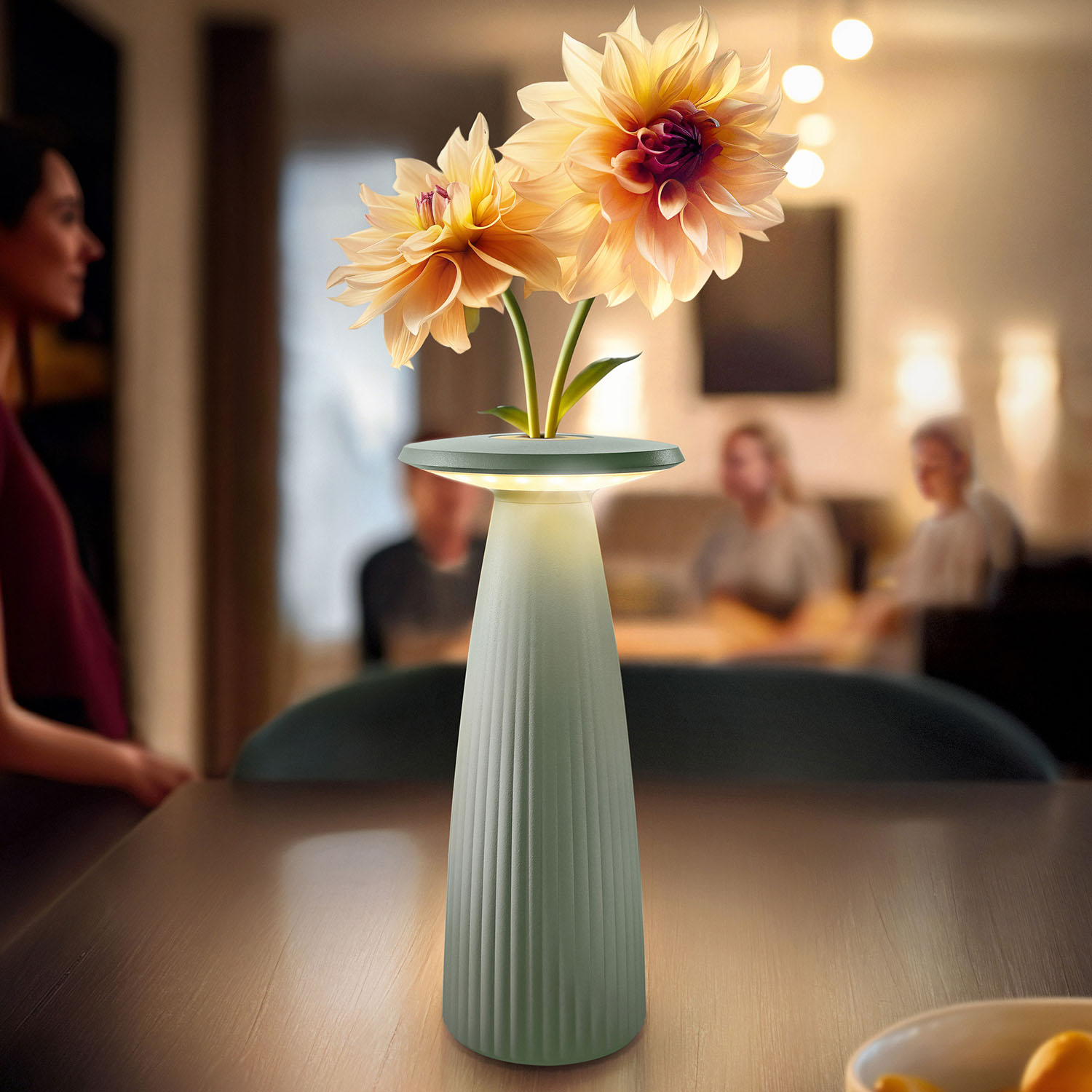 Eine beleuchtete Lampe mit Blumen auf einem Tisch, unscharfe Personen im Hintergrund.