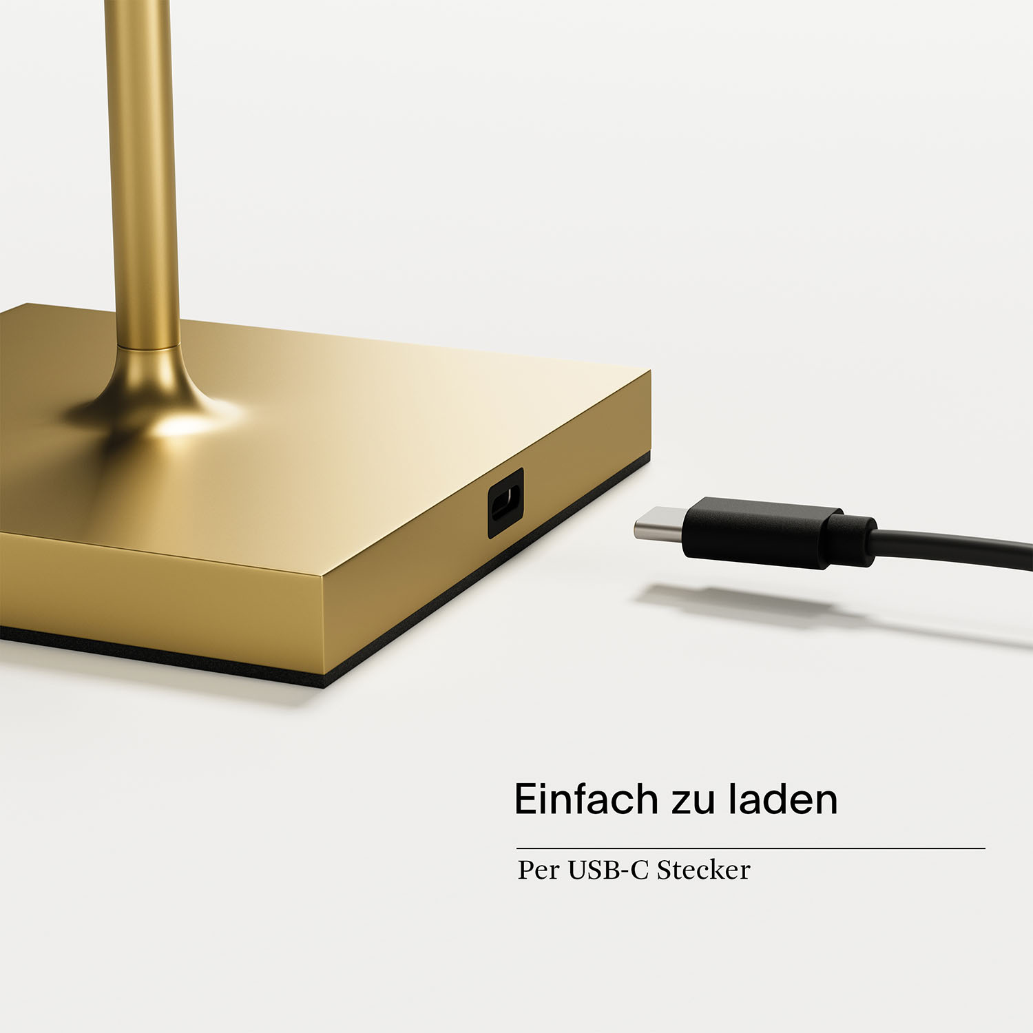 Ein goldfarbener Lampensockel mit USB-C-Ladeanschluss. Ein schwarzes USB-C-Kabel ist eingesteckt, weißer Hintergrund.