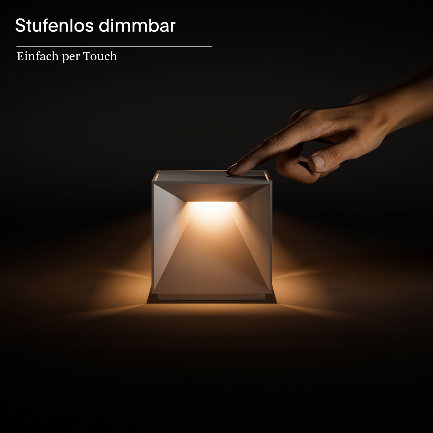 Eine quadratische Lampe mit Licht, das aus ihr heraus scheint. Eine Hand berührt die Oberfläche.
