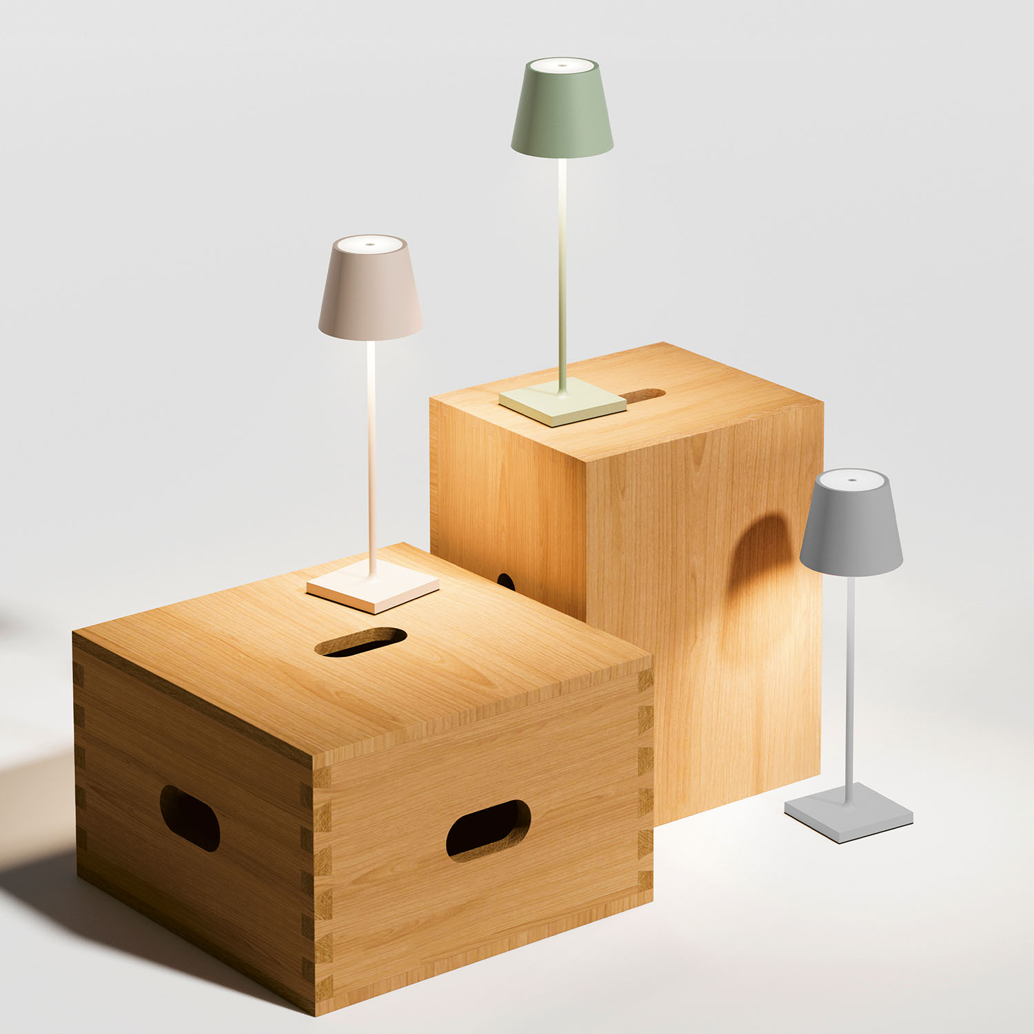 Drei kleine Lampen in verschiedenen Farben auf Holzblöcken. Der Hintergrund ist weiß.