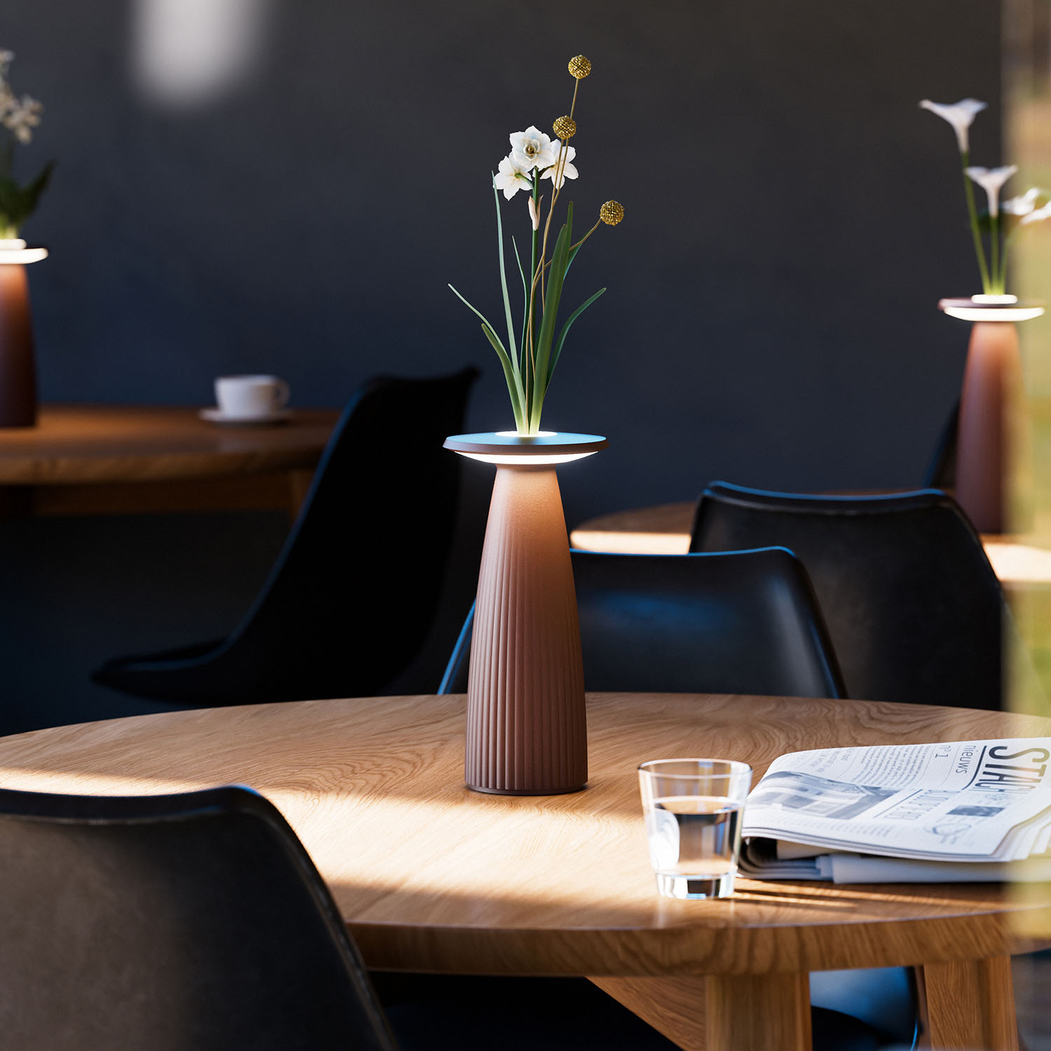 Tischlampe mit Blumen in Vase, Wasserglas und Zeitung auf Holztisch im Restaurant.