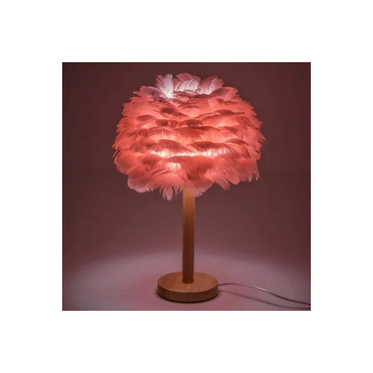 Rosa Feder-Lampenschirm auf Holzständer. Von innen beleuchtet, wirft einen rosa Schein auf rosa Hintergrund.