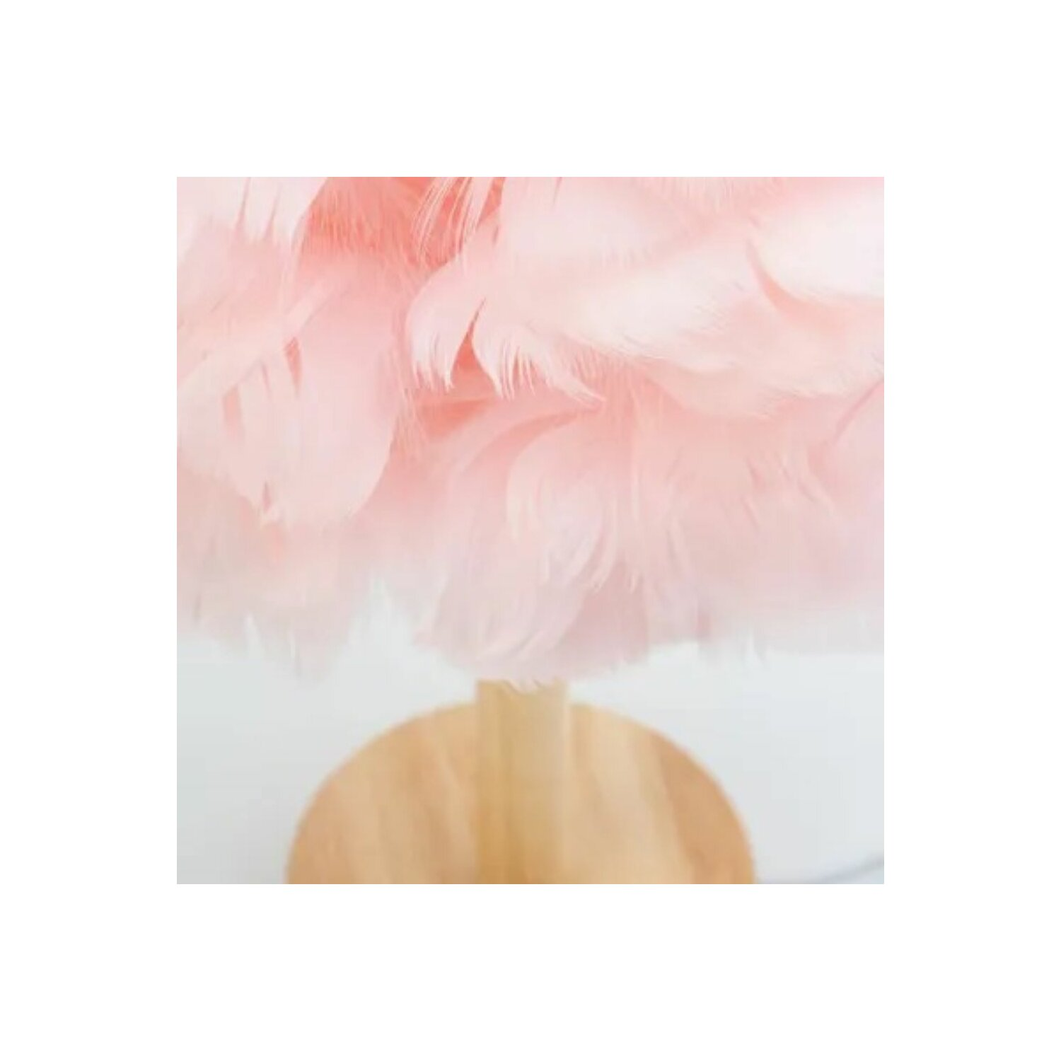 Nahaufnahme eines rosa, flauschigen Lampenschirms mit Holzsockel.