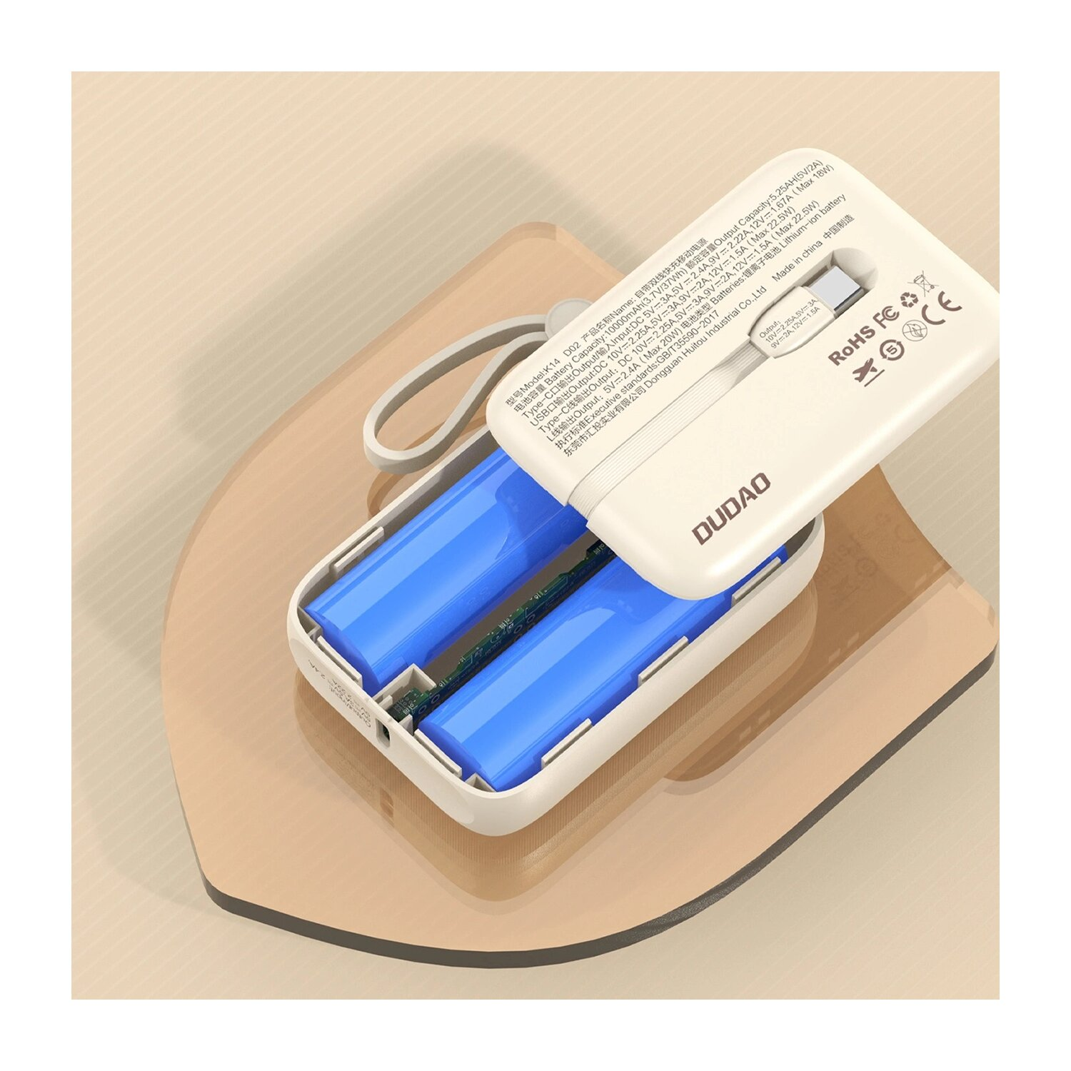 Power bank bianco con due batterie blu all'interno. Superficie beige, sfondo chiaro.