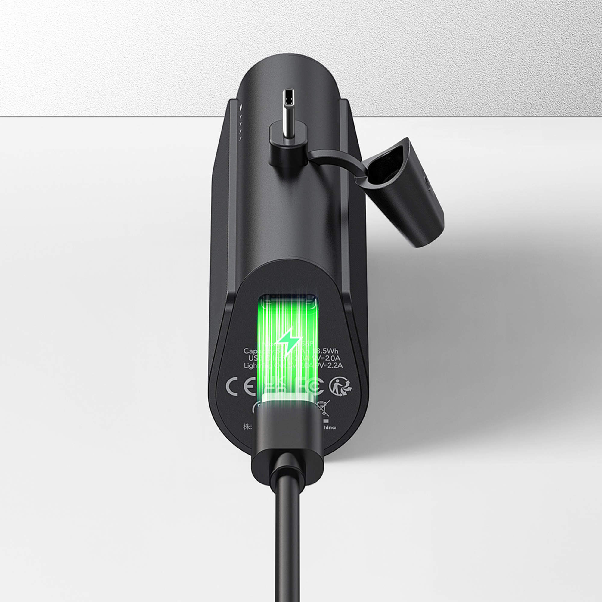 Czarna ładowarka z kablem USB i zielonym wskaźnikiem naładowania baterii.