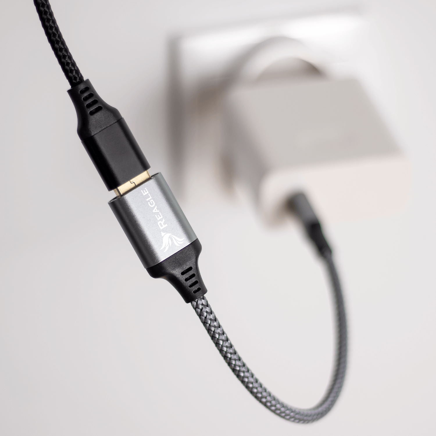 Kabel USB-C podłączony do ładowarki i adaptera, na białym tle.