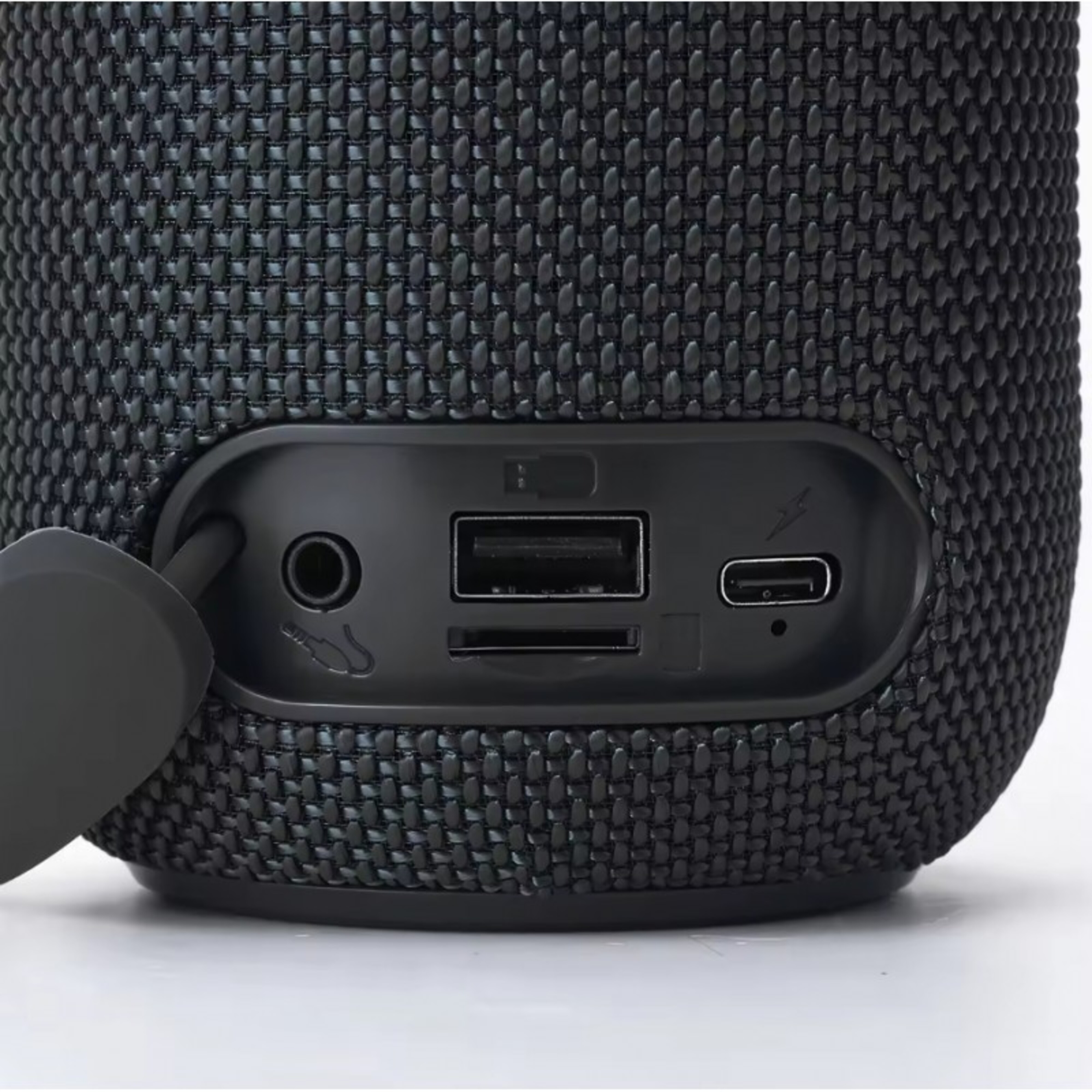 Primer plano de un altavoz negro con varios puertos y botones visibles.