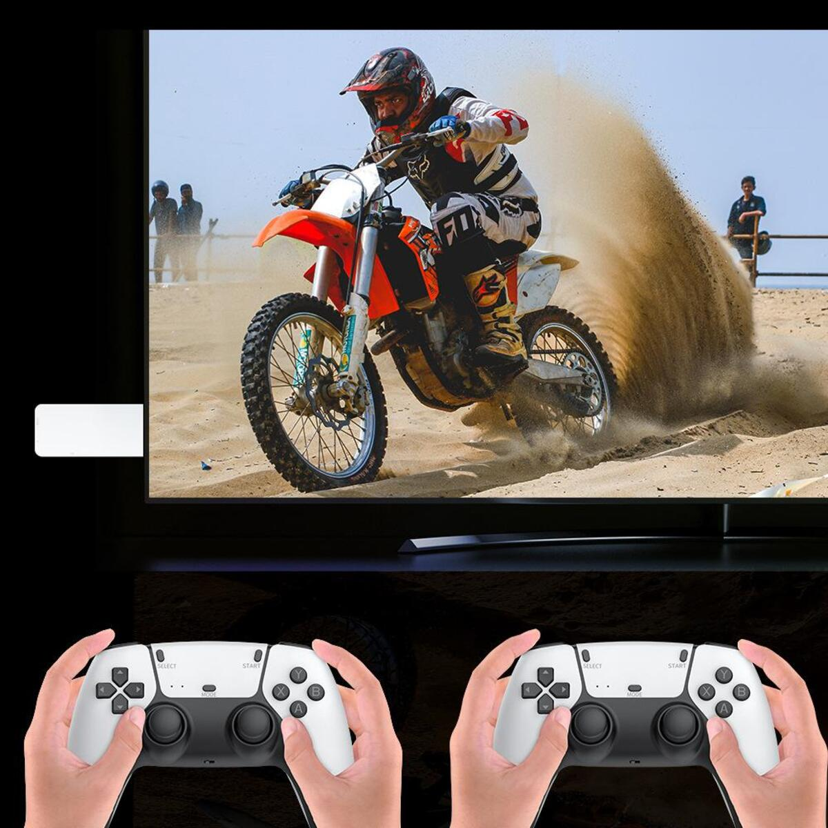 Una persona en una motocicleta corriendo en una playa. Dos manos sosteniendo mandos. Fondo: un televisor.