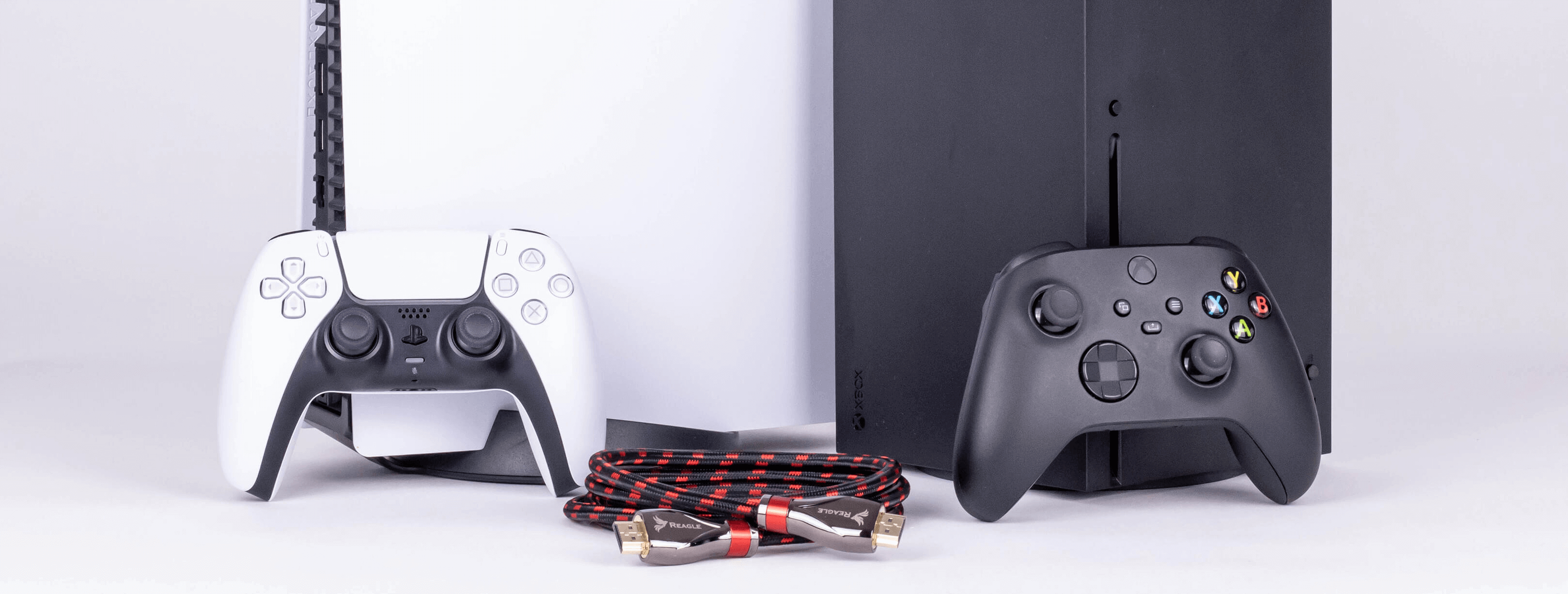 Konsola PlayStation 5 i Xbox Series X z kontrolerami, kablem HDMI. Wszystko na białym tle.