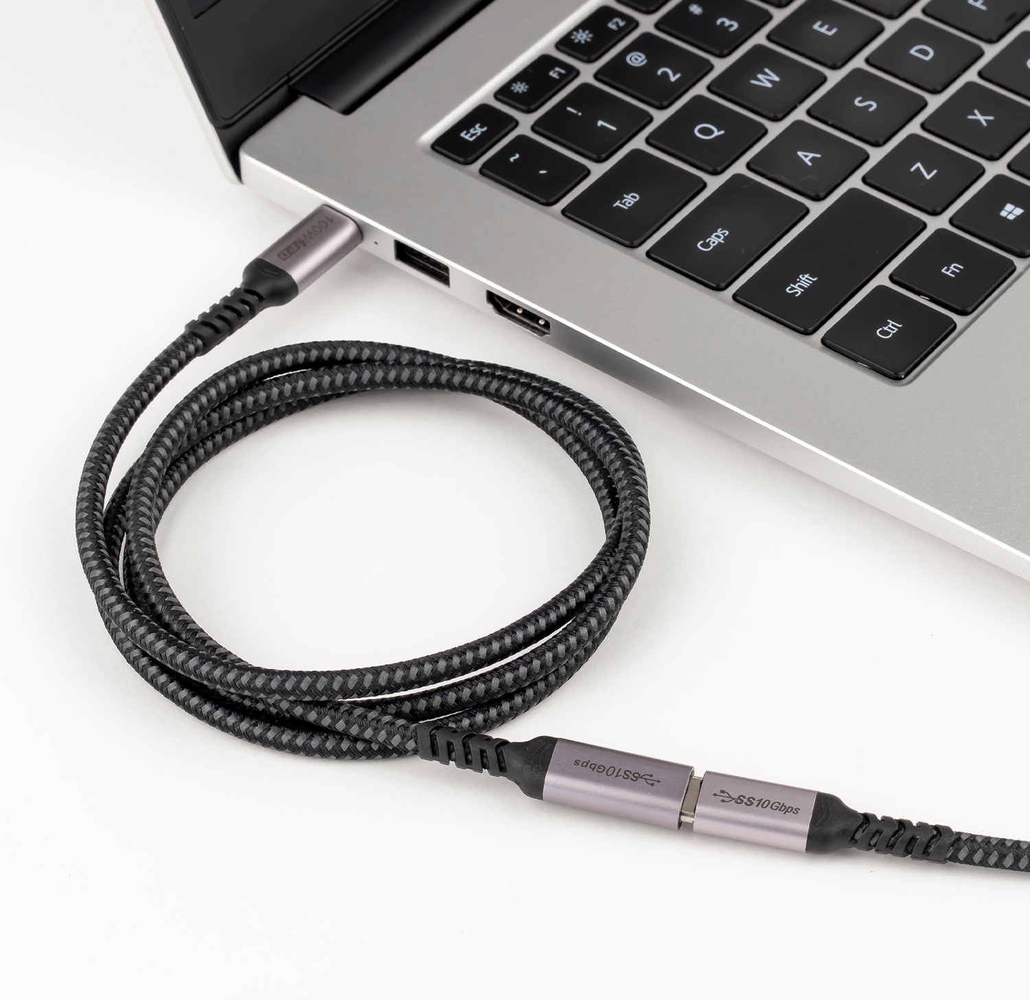 Czarny i szary kabel USB-C podłączony do laptopa. Białe tło.