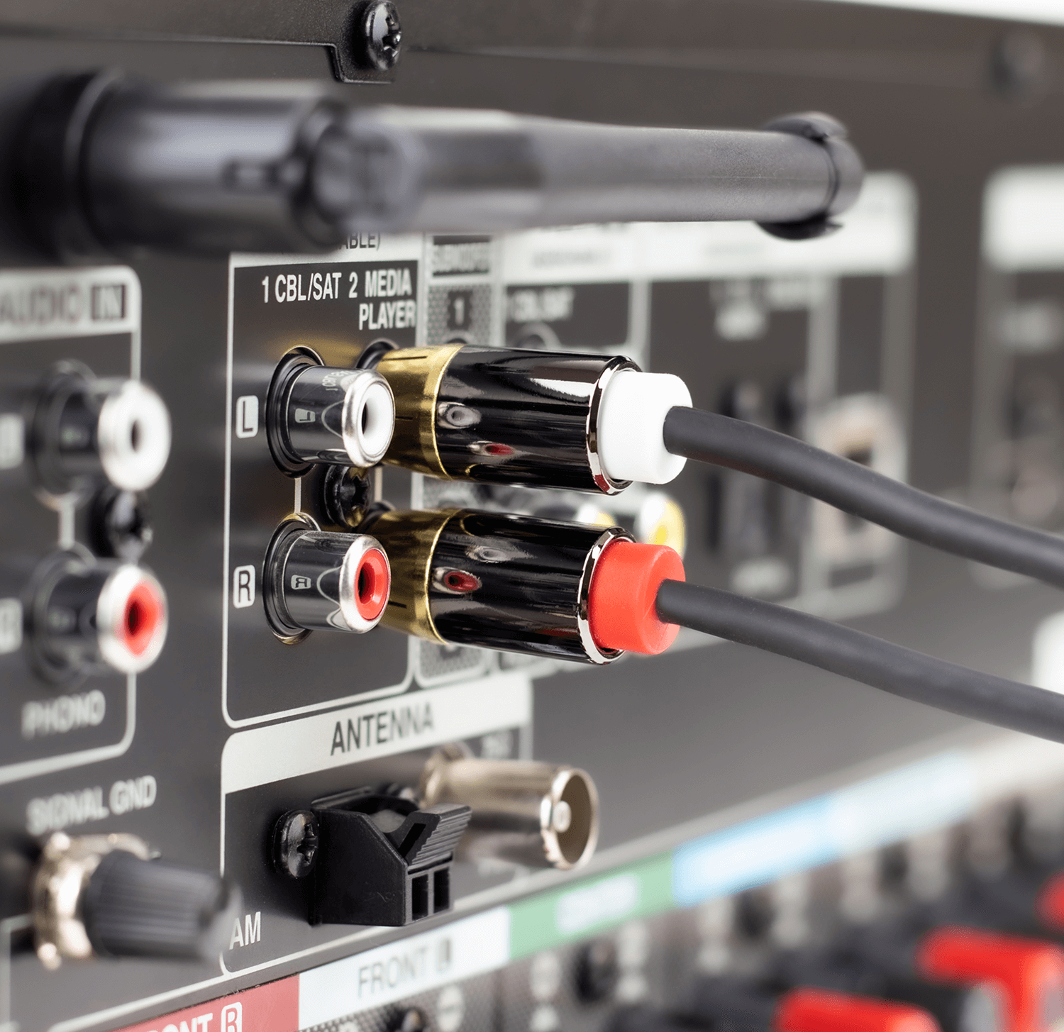 Zbliżenie kabli audio podłączonych do tyłu odbiornika audio.