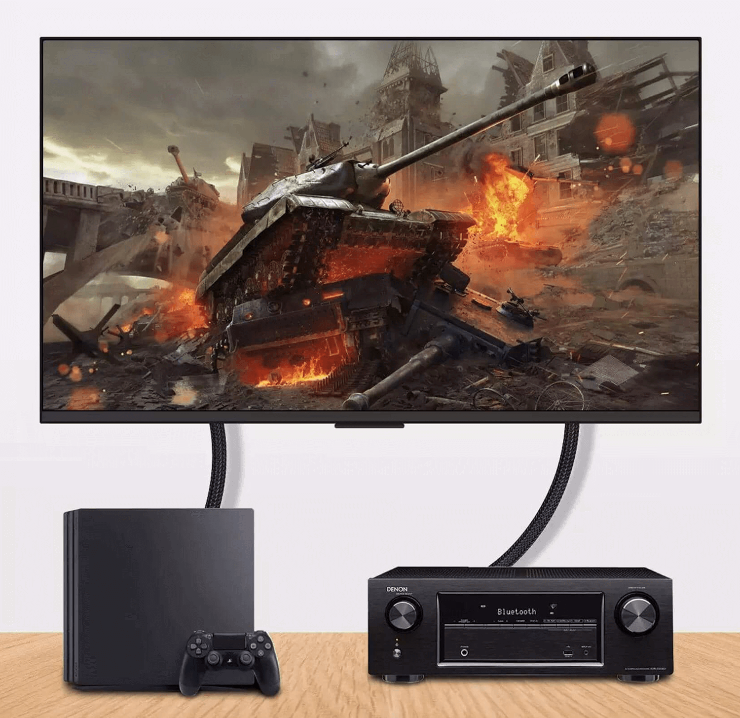 Ekran telewizora przedstawia scenę wojenną. Poniżej znajdują się PlayStation i odbiornik na drewnie.