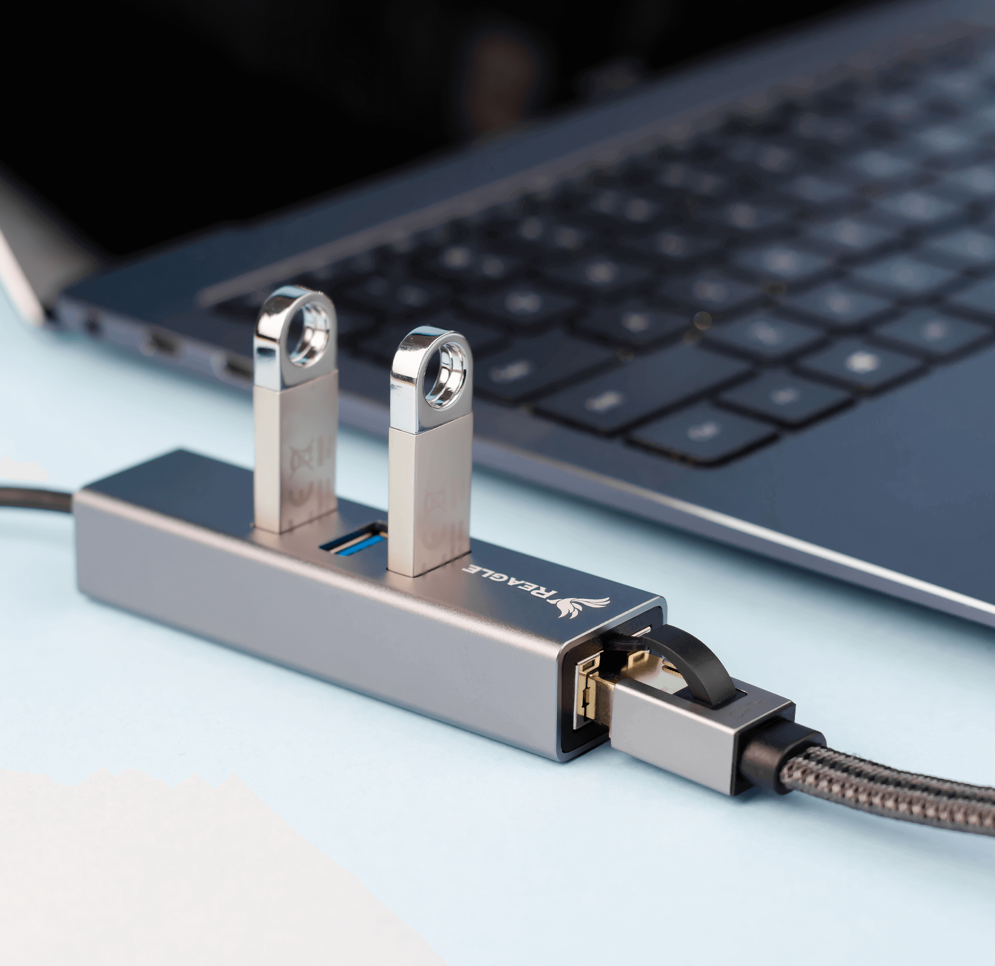 Hub USB z dwoma podłączonymi dyskami USB, obok laptopa.