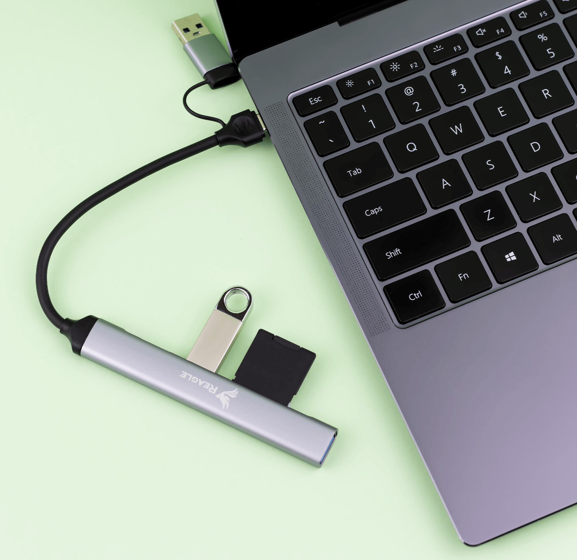 Hub USB argentato con varie porte collegato a un laptop.