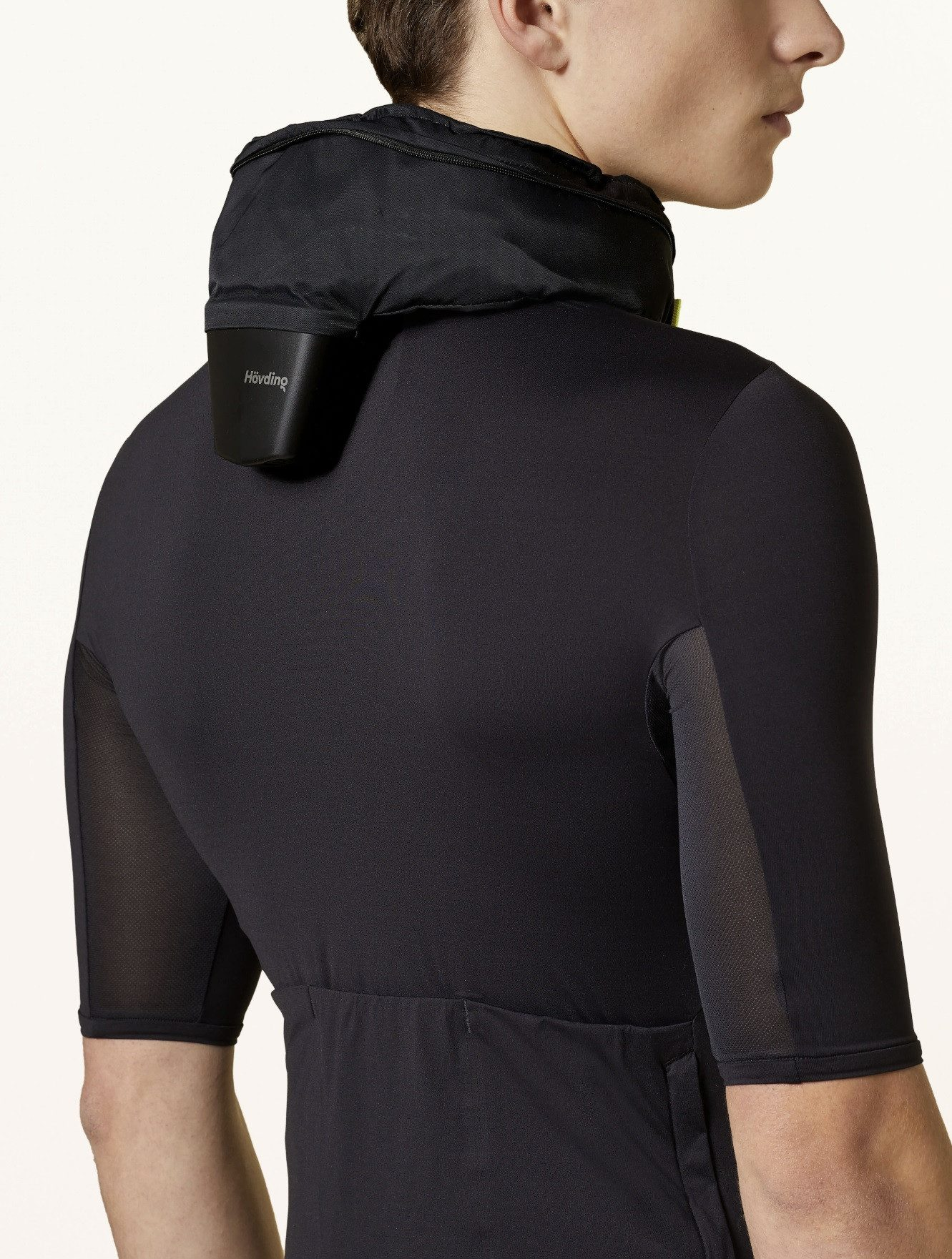 Eine Person trägt ein schwarzes Radsport-Outfit mit einer schwarzen Nackenstütze.