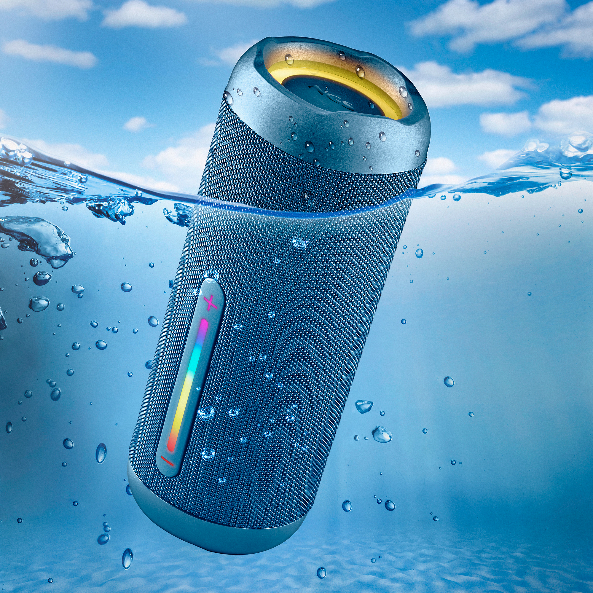 Niebieski głośnik jest zanurzony w wodzie z bąbelkami. Głośnik ma kolorowy pasek świetlny.