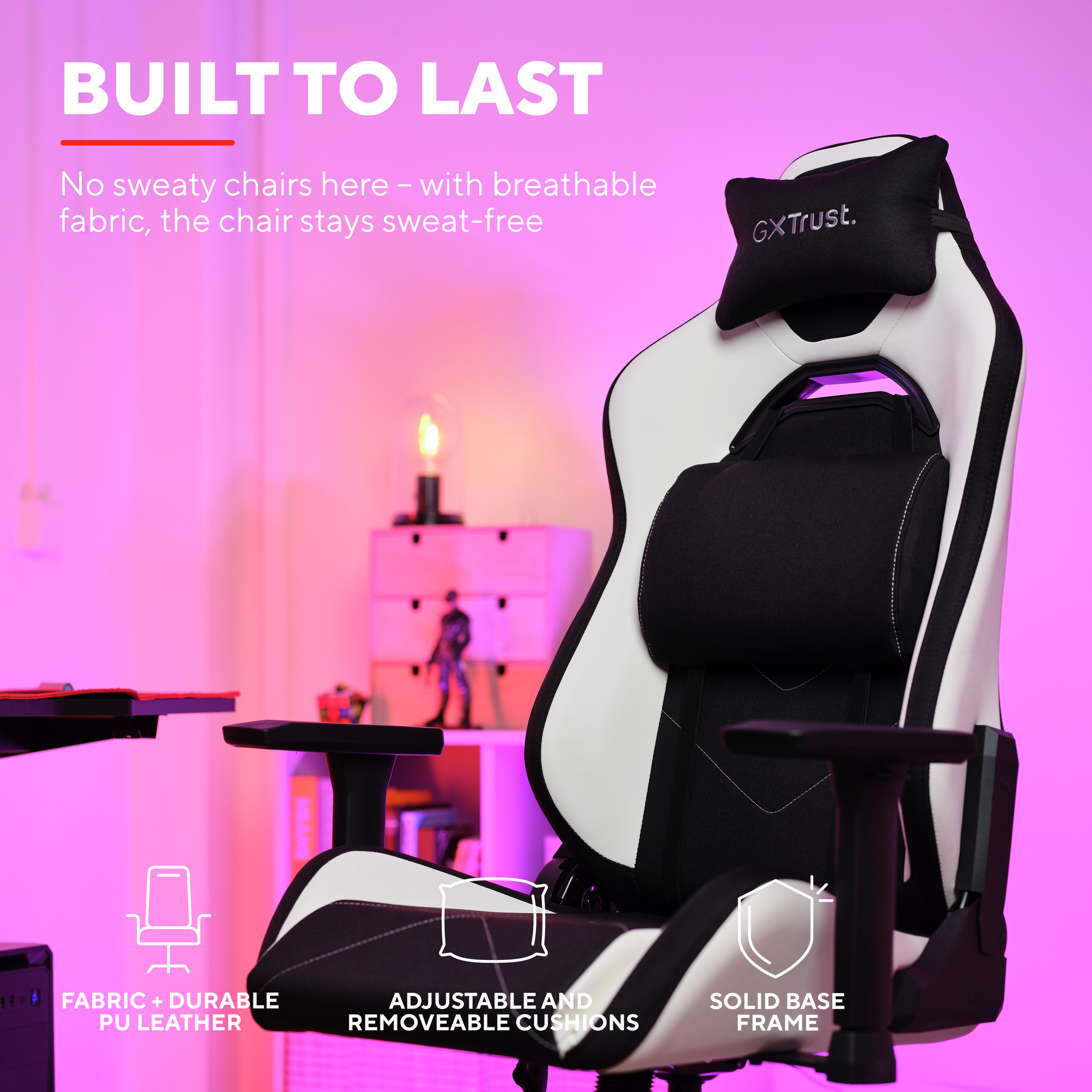 Biało-czarny fotel gamingowy. Ma poduszkę pod głowę i podparcie pleców. Tło jest różowe.