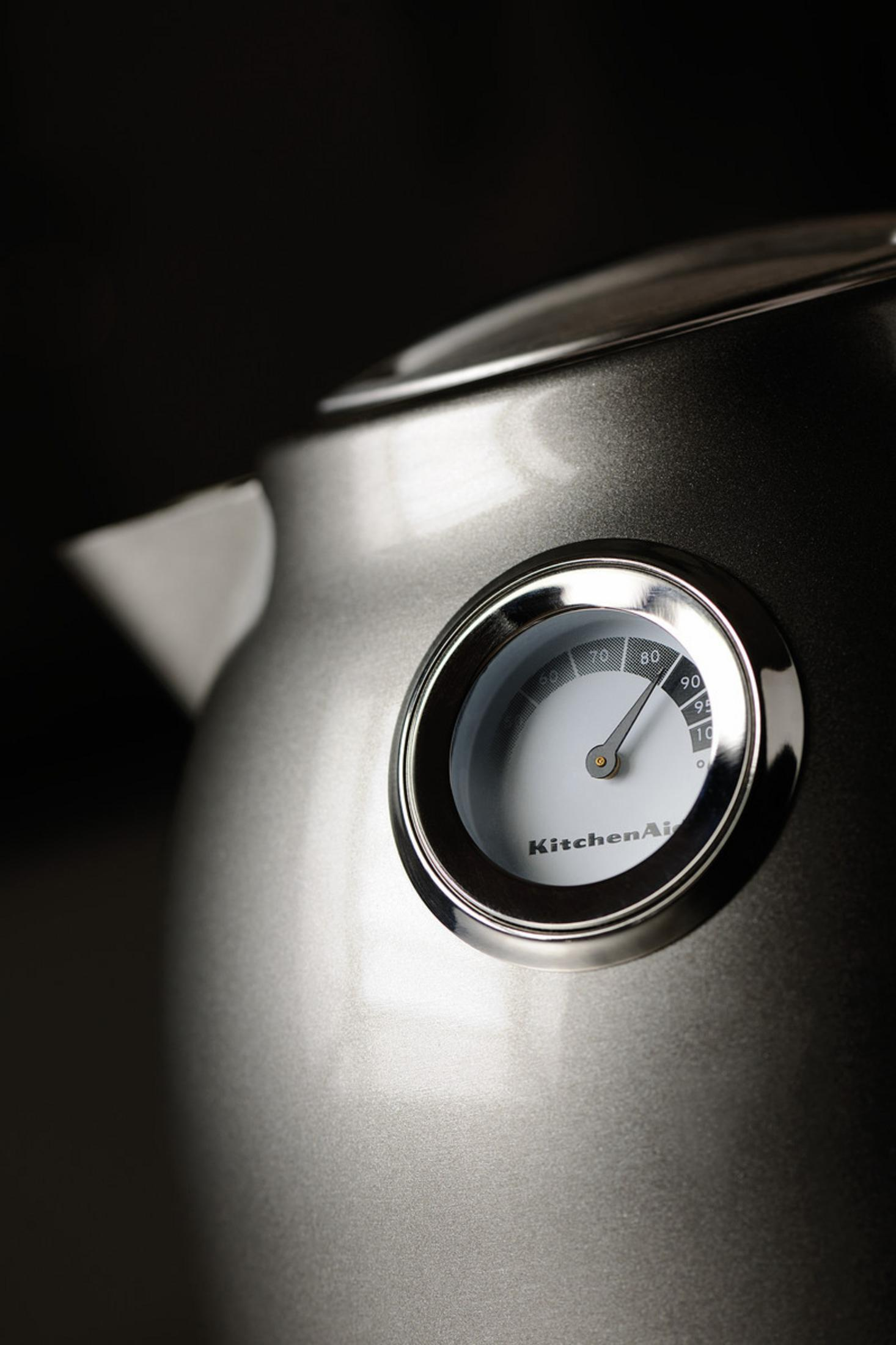 Zbliżenie srebrnego czajnika elektrycznego ze wskaźnikiem temperatury.