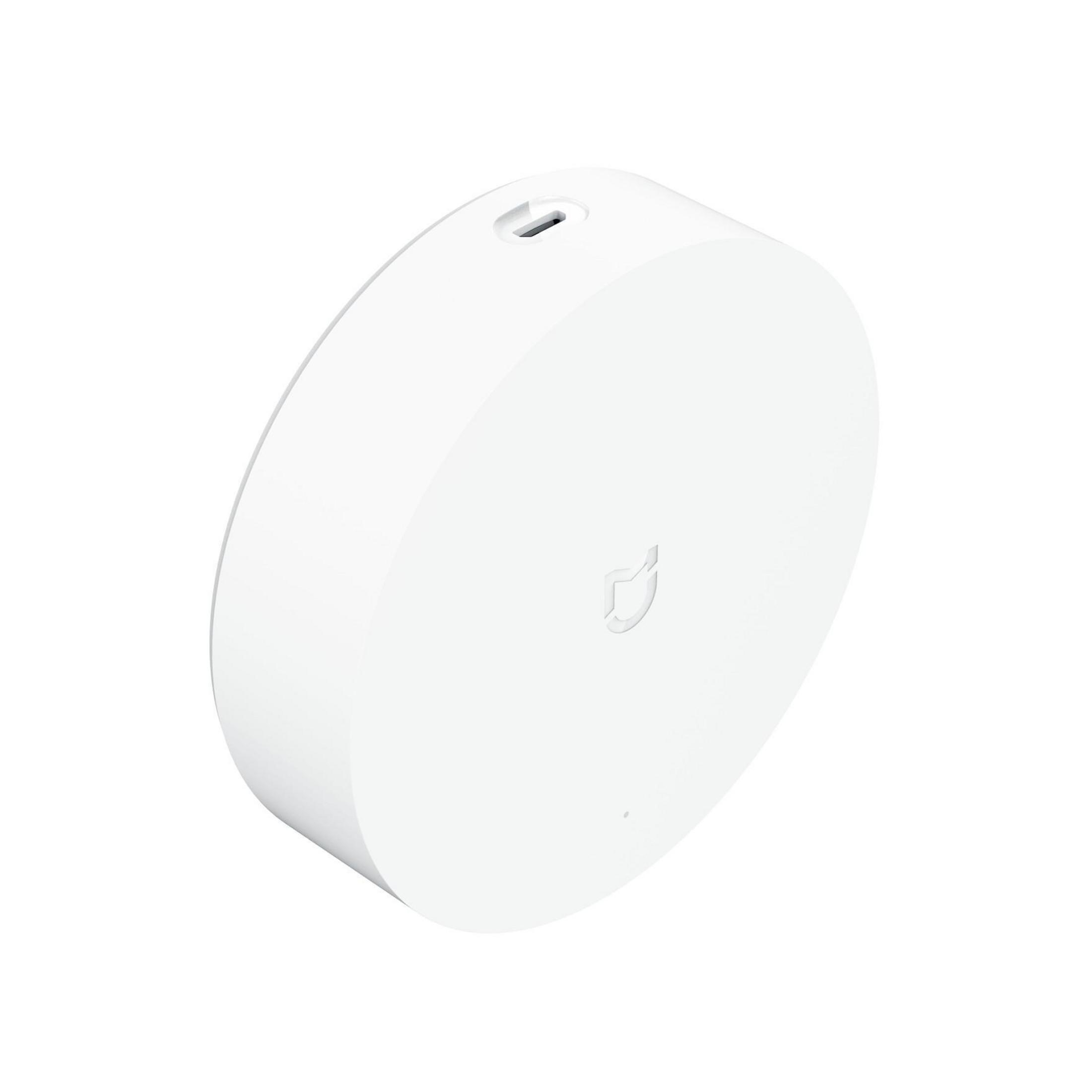 Dispositivo per la casa intelligente circolare bianco con un logo sulla superficie.