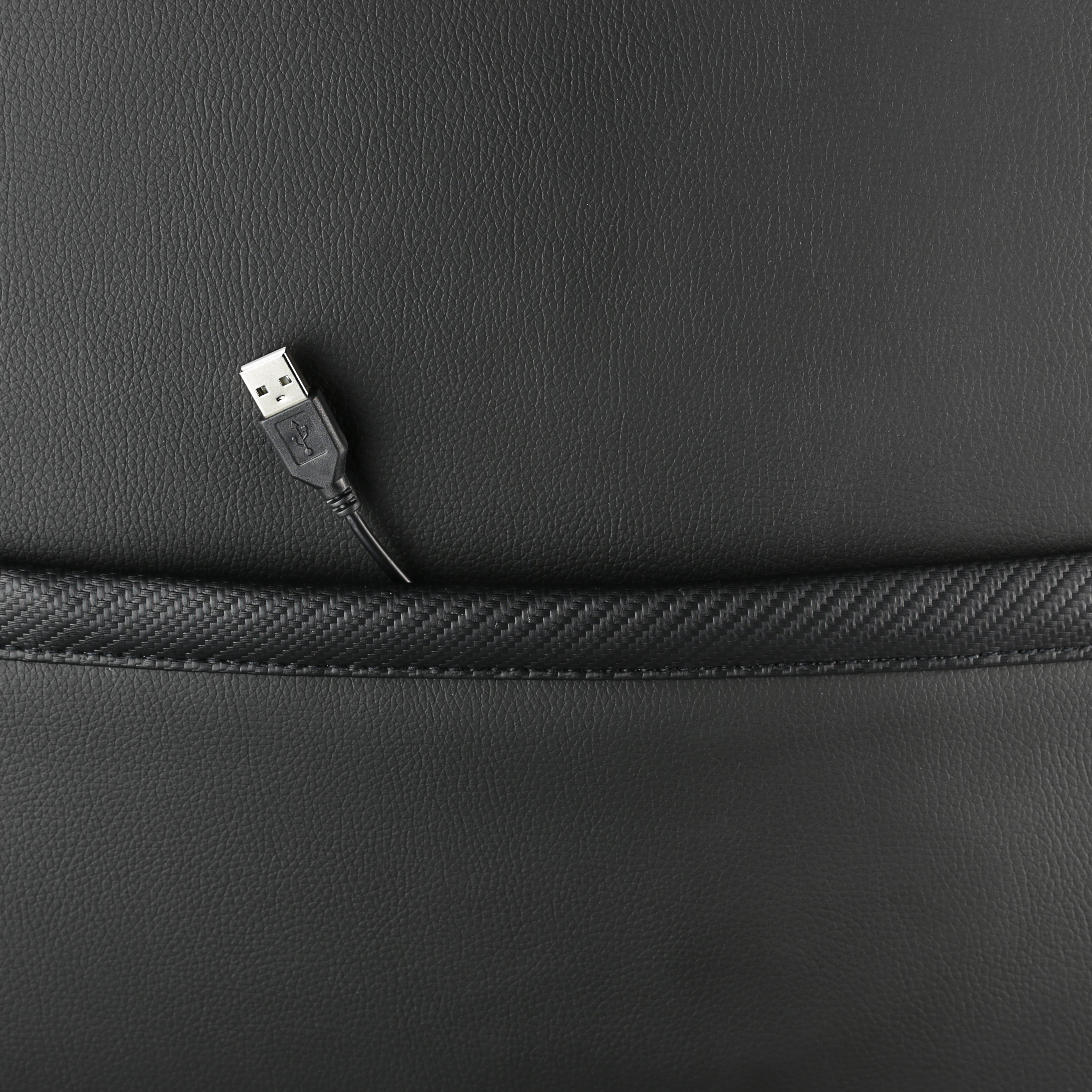 USB-Kabel in einer schwarzen Ledertasche. Schwarzer Ledertextur-Hintergrund.