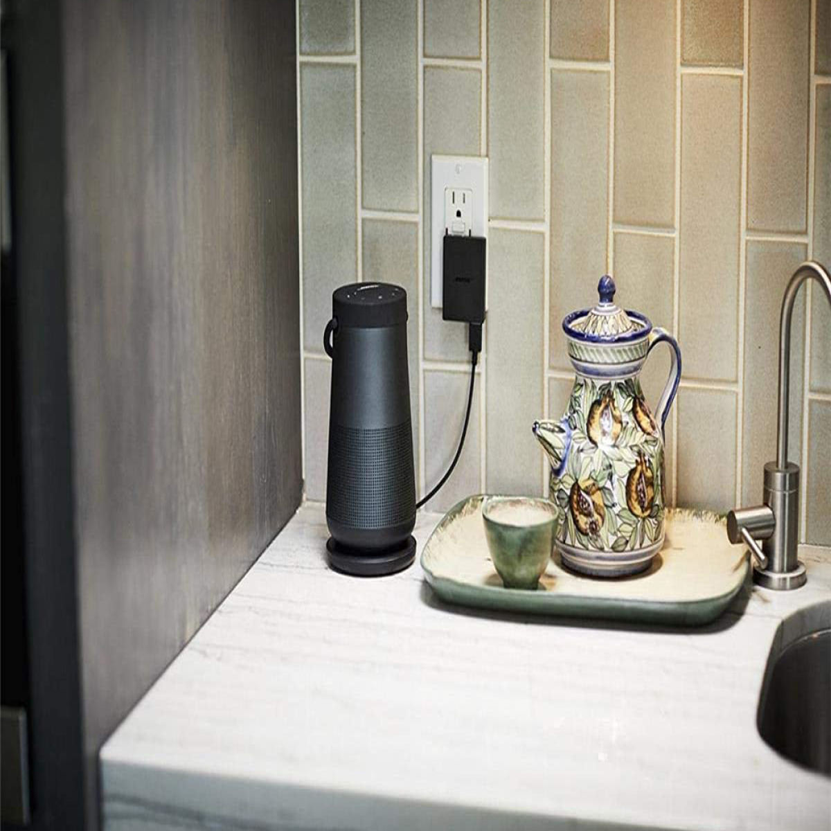 Küchentheke mit einem Smart Speaker, einer Ladestation und einem Teeservice.