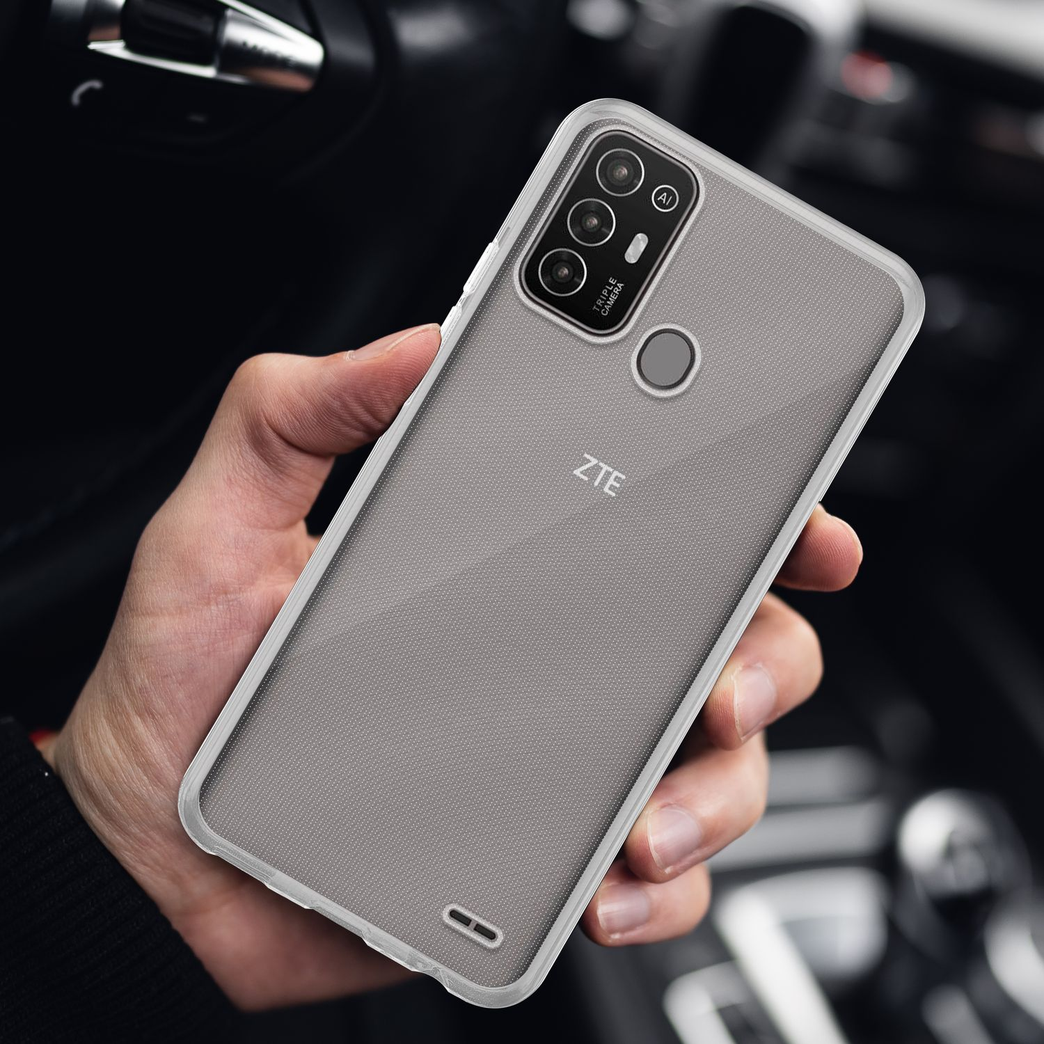 Una persona tiene una custodia trasparente su un telefono grigio. Il telefono ha tre fotocamere.
