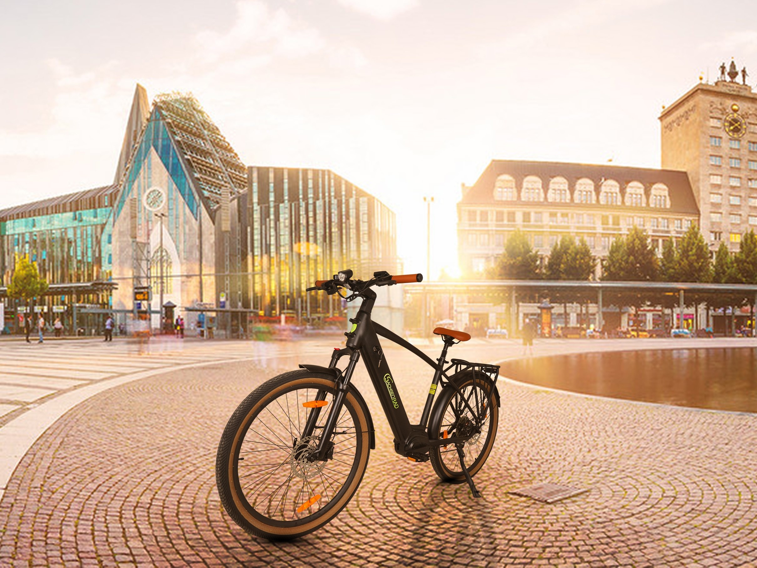 Schwarzes Fahrrad auf Kopfsteinpflaster, Gebäude und Sonnenuntergang im Hintergrund.