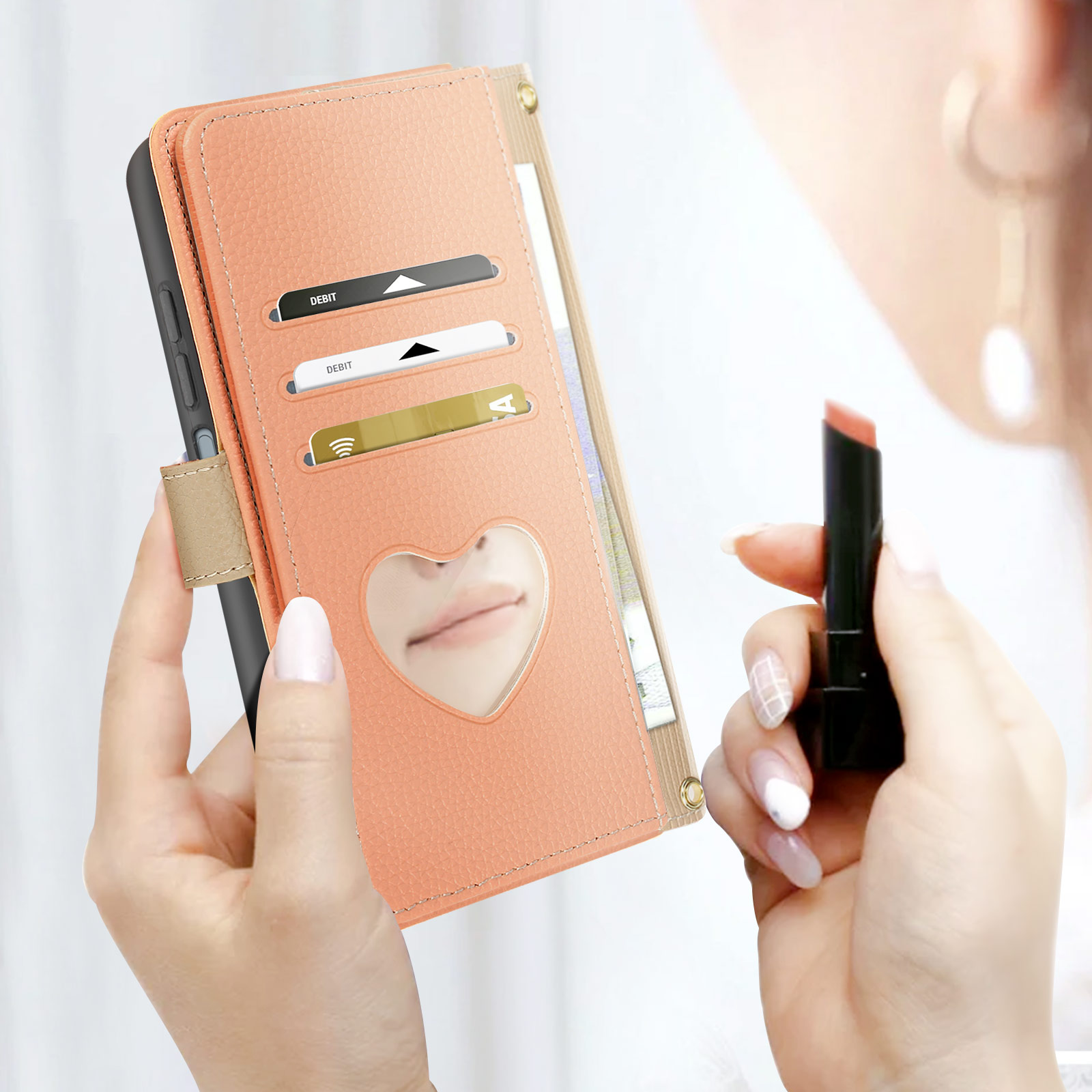 Mani di donna che tengono una custodia per telefono color pesca. Un rossetto è visibile. La custodia ha fessure per carte.