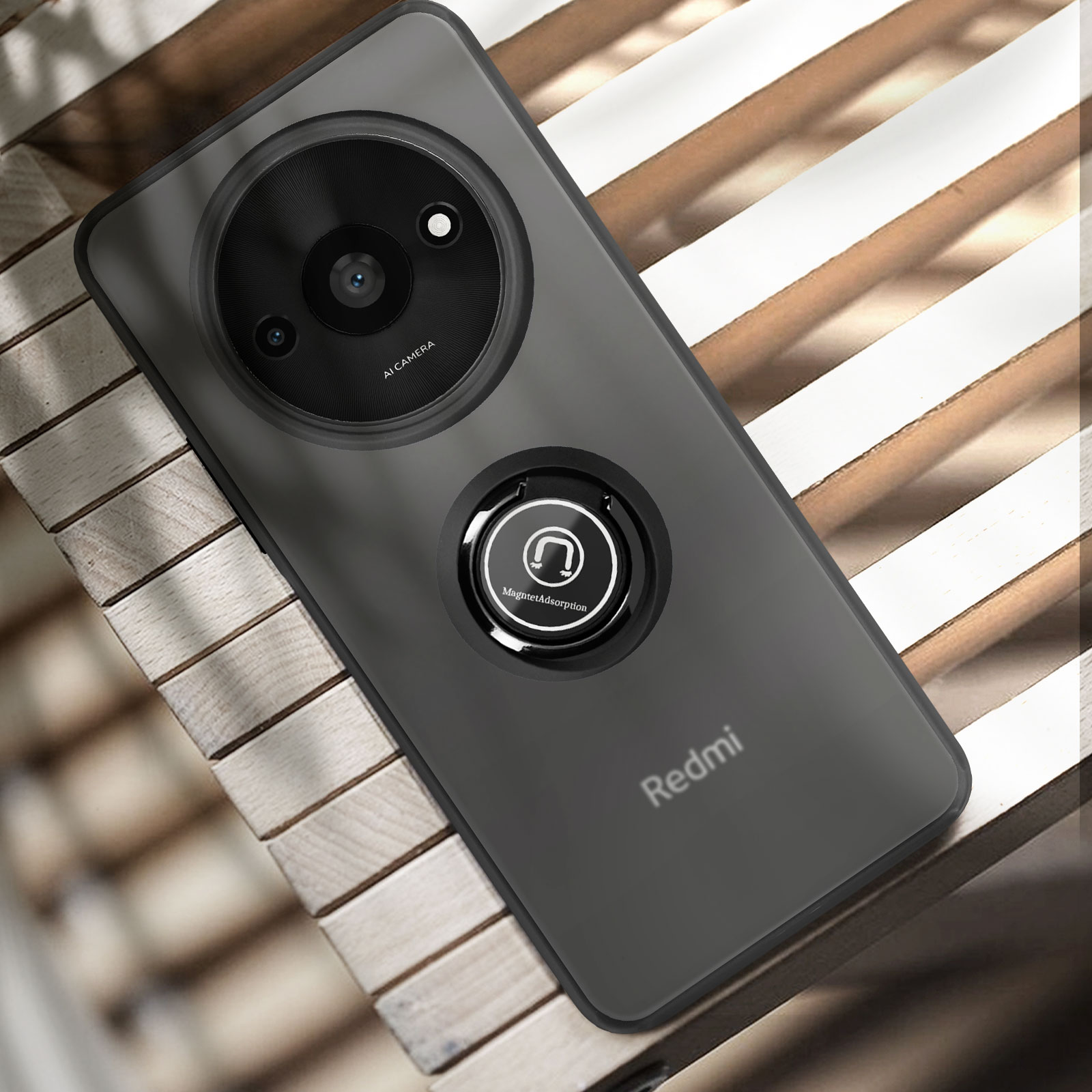 Custodia per telefono Redmi grigio scuro con supporto per anello fotocamera. Il telefono è su legno.