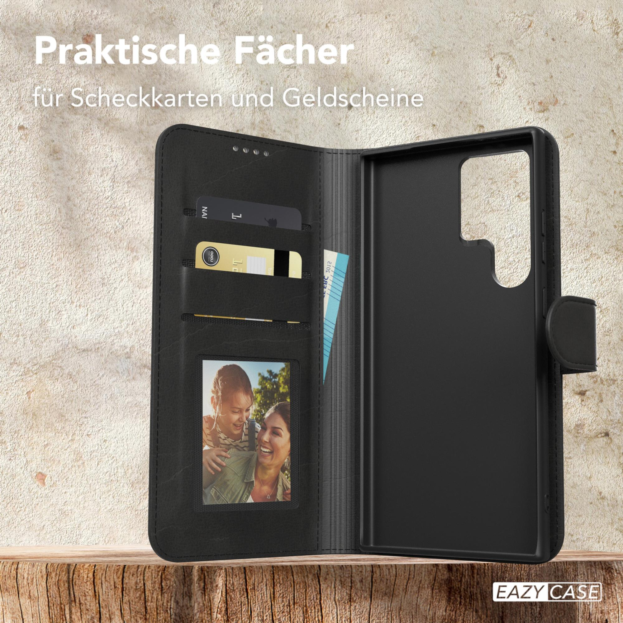 Schwarze Handyhülle mit Fächern für Karten und ein Foto. Geöffnet, zeigt den Inhalt, auf Holzoberfläche.