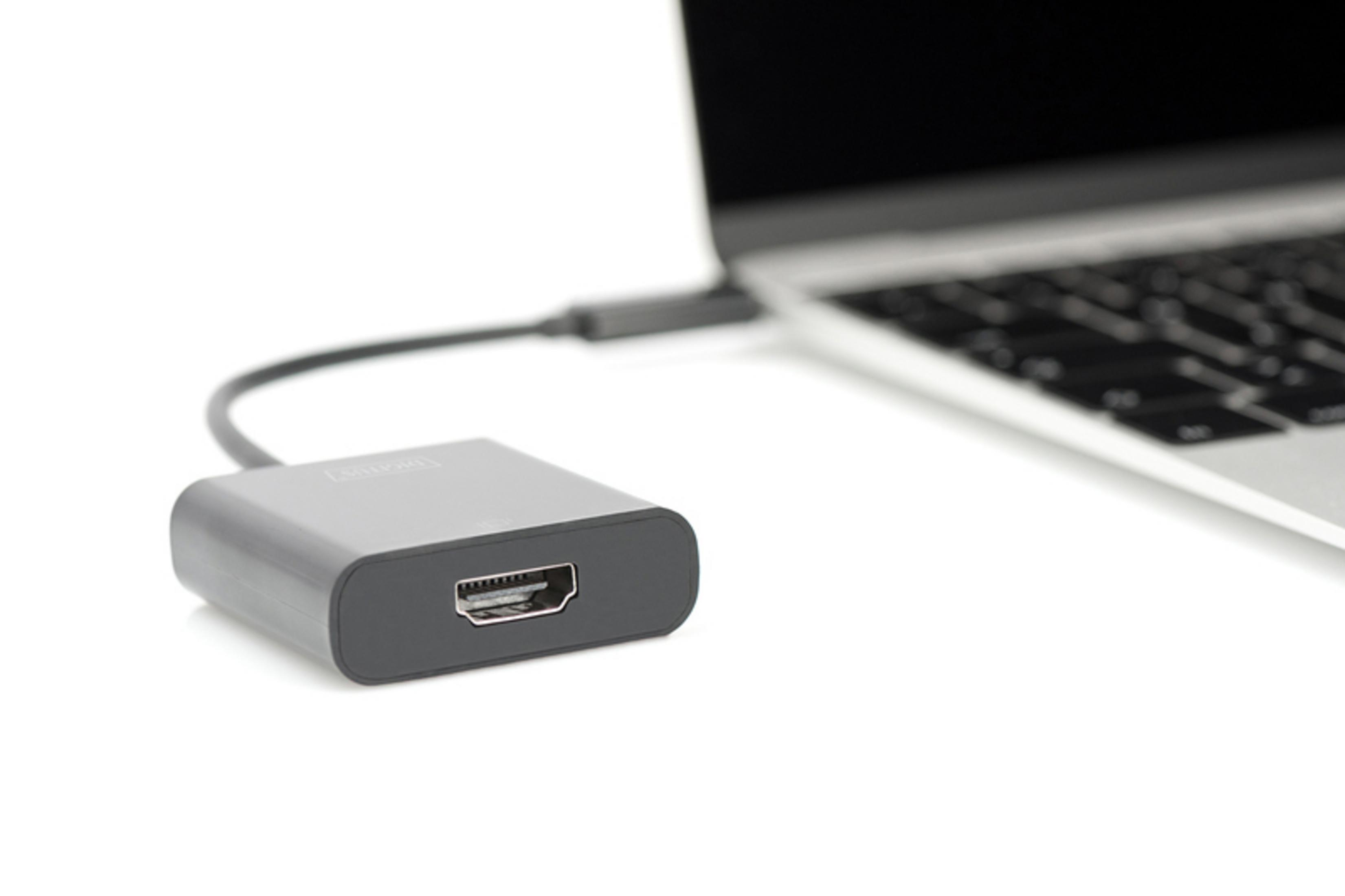 Bir HDMI adaptörü bir dizüstü bilgisayara bağlı. Adaptör gümüş rengi ve dizüstü bilgisayar açık.