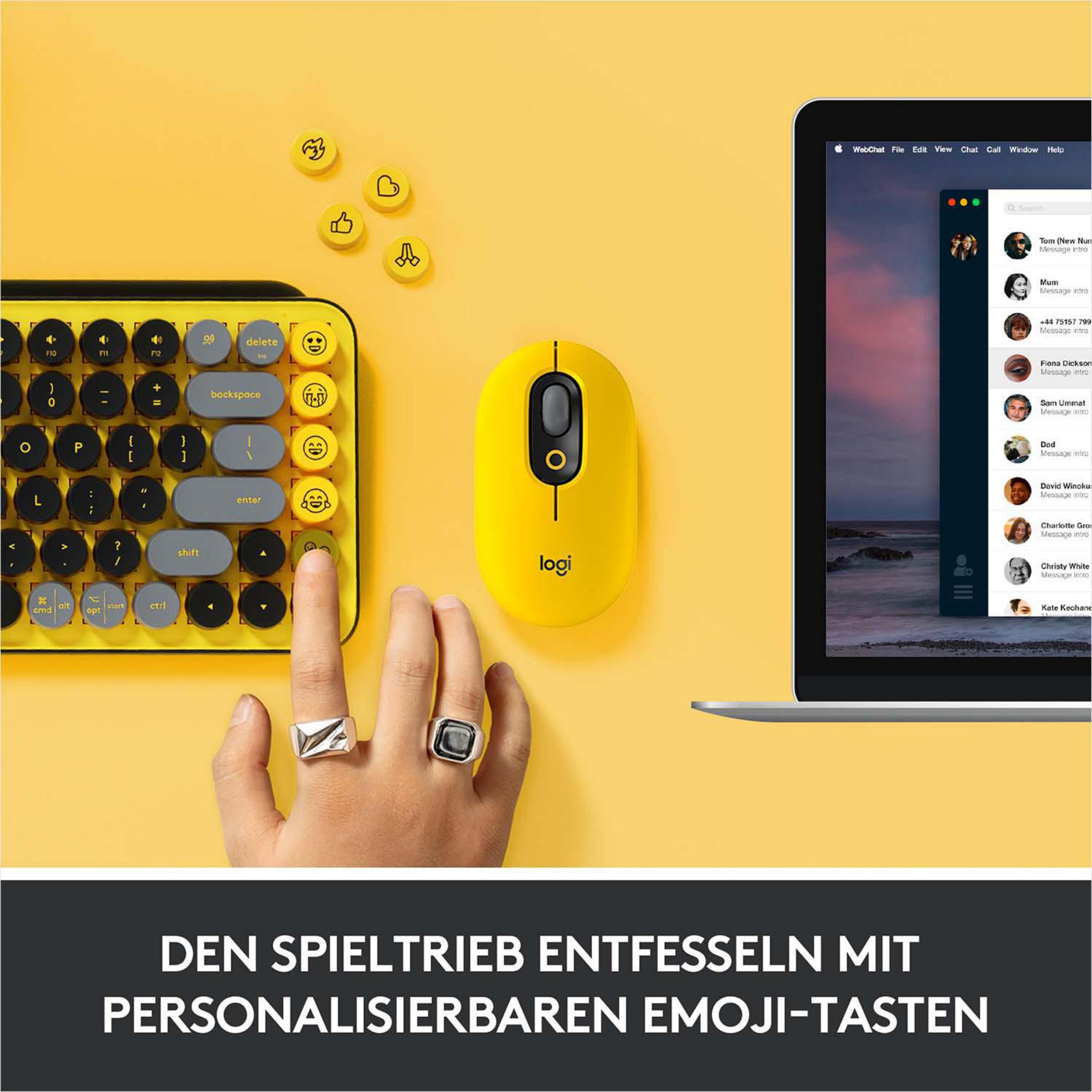 Eine gelbe Tastatur, Maus und eine Hand mit Ringen auf gelber Oberfläche mit Laptop.