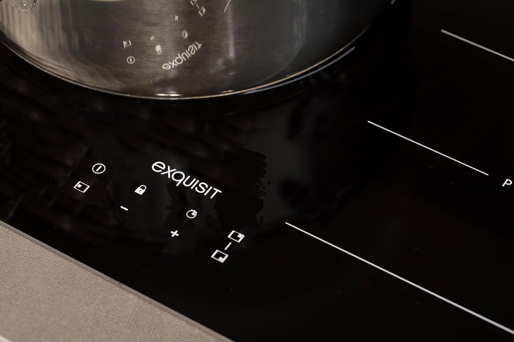 Placa de inducción negra con controles táctiles y una olla.