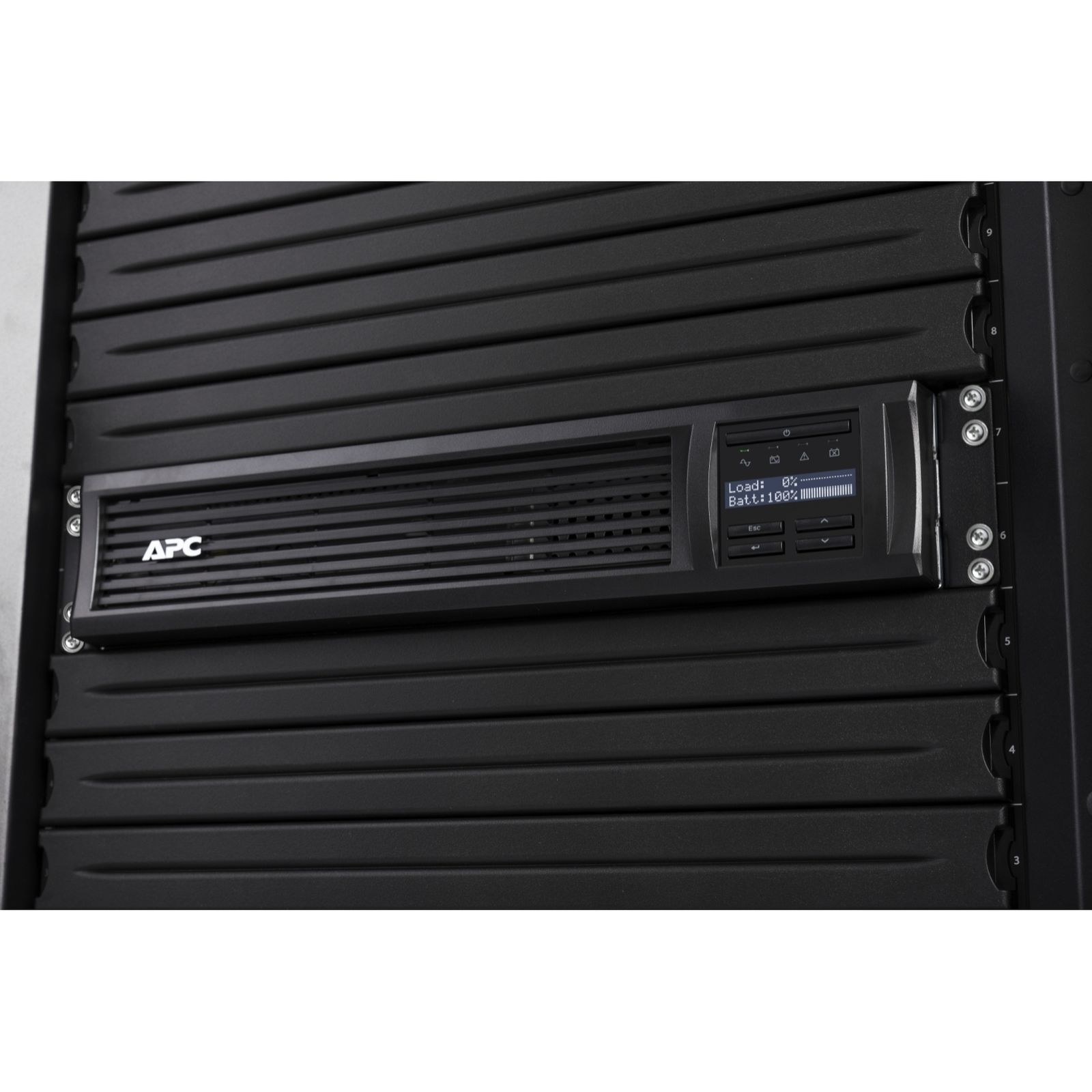 SAI APC montado en rack con una pantalla que muestra la carga y el estado de la batería, montado en un rack negro.