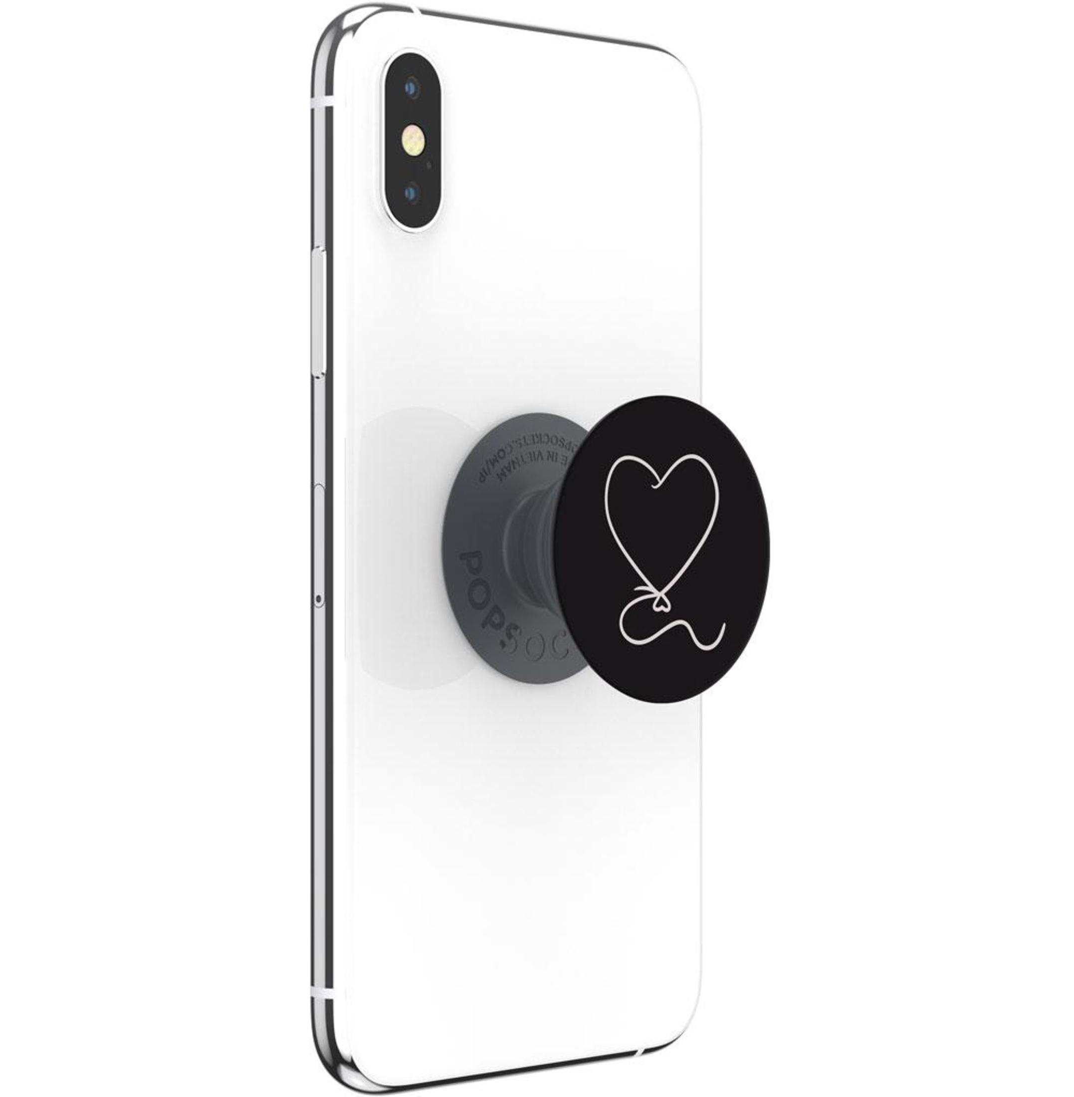 Ein weißes Telefon mit einem schwarzen PopSocket. Der PopSocket hat ein weißes Herzdesign.