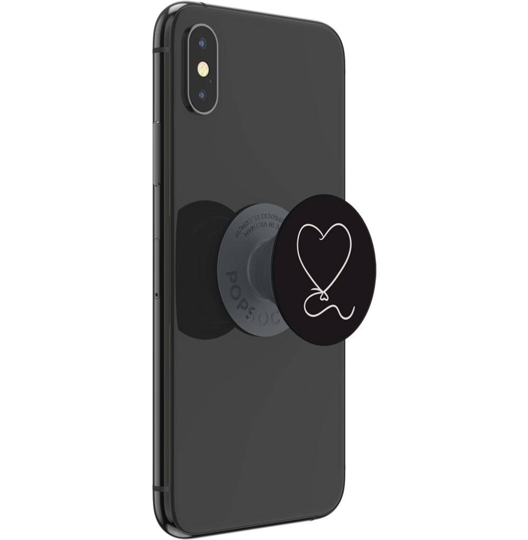 Schwarzes Telefon mit Popsocket. Popsocket hat ein weißes Herzdesign. Telefon auf weißem Hintergrund.