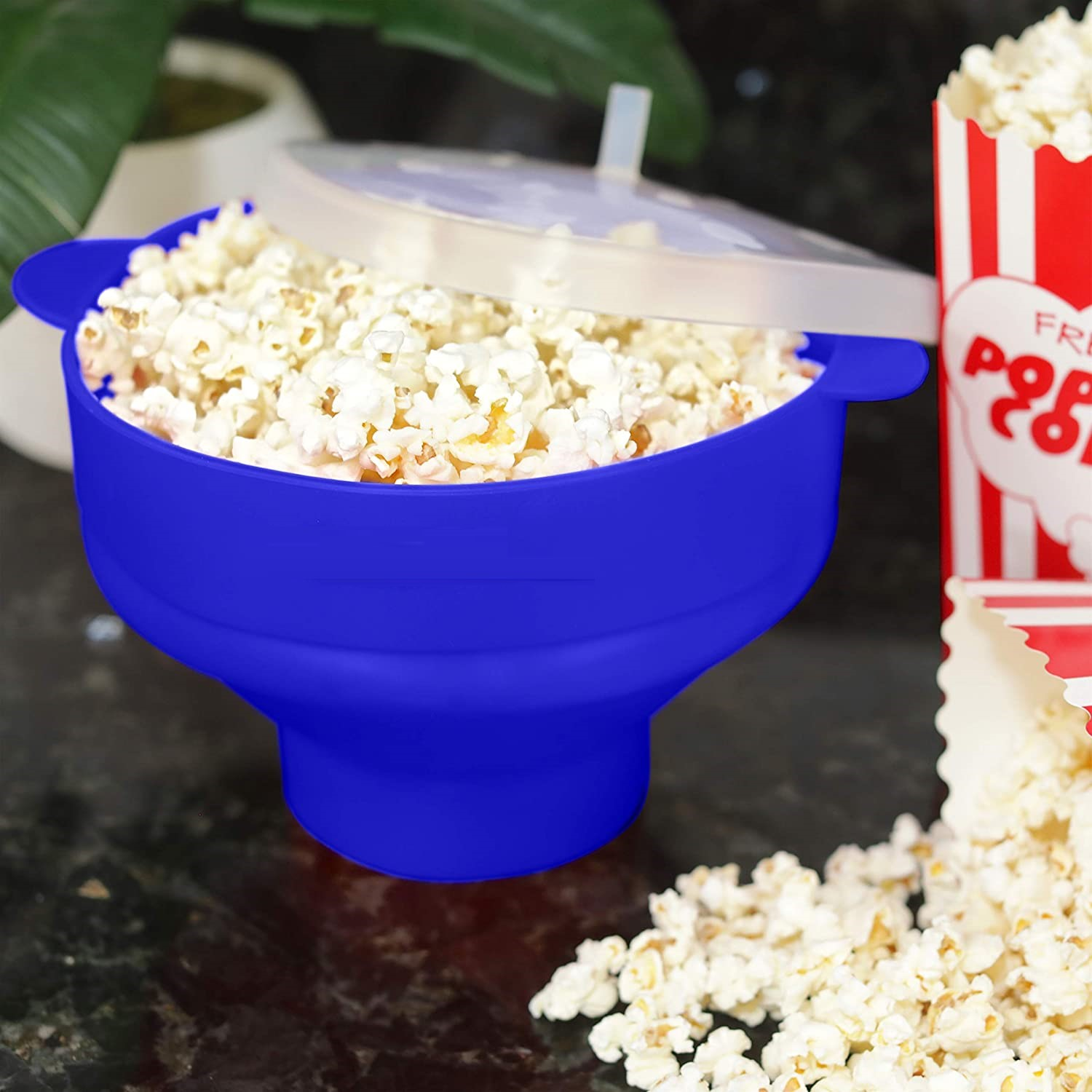 Blue popcorn maker with popcorn inside, and a popcorn box beside it.