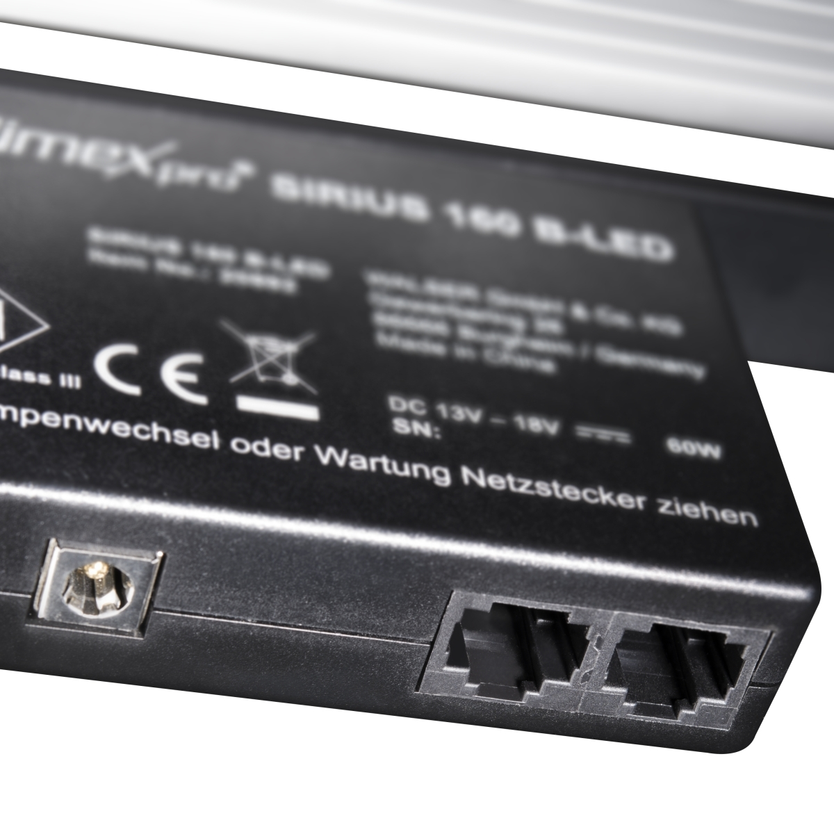 Schwarzes elektronisches Gerät mit Anschlüssen und Text. Es hat einen Stromeingang und Netzwerkanschlüsse.