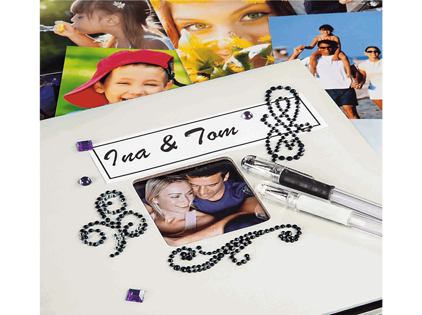 Album fotograficzny ze zdjęciami, kryształkami i długopisami. Album jest otwarty, z tekstem i zdjęciami.