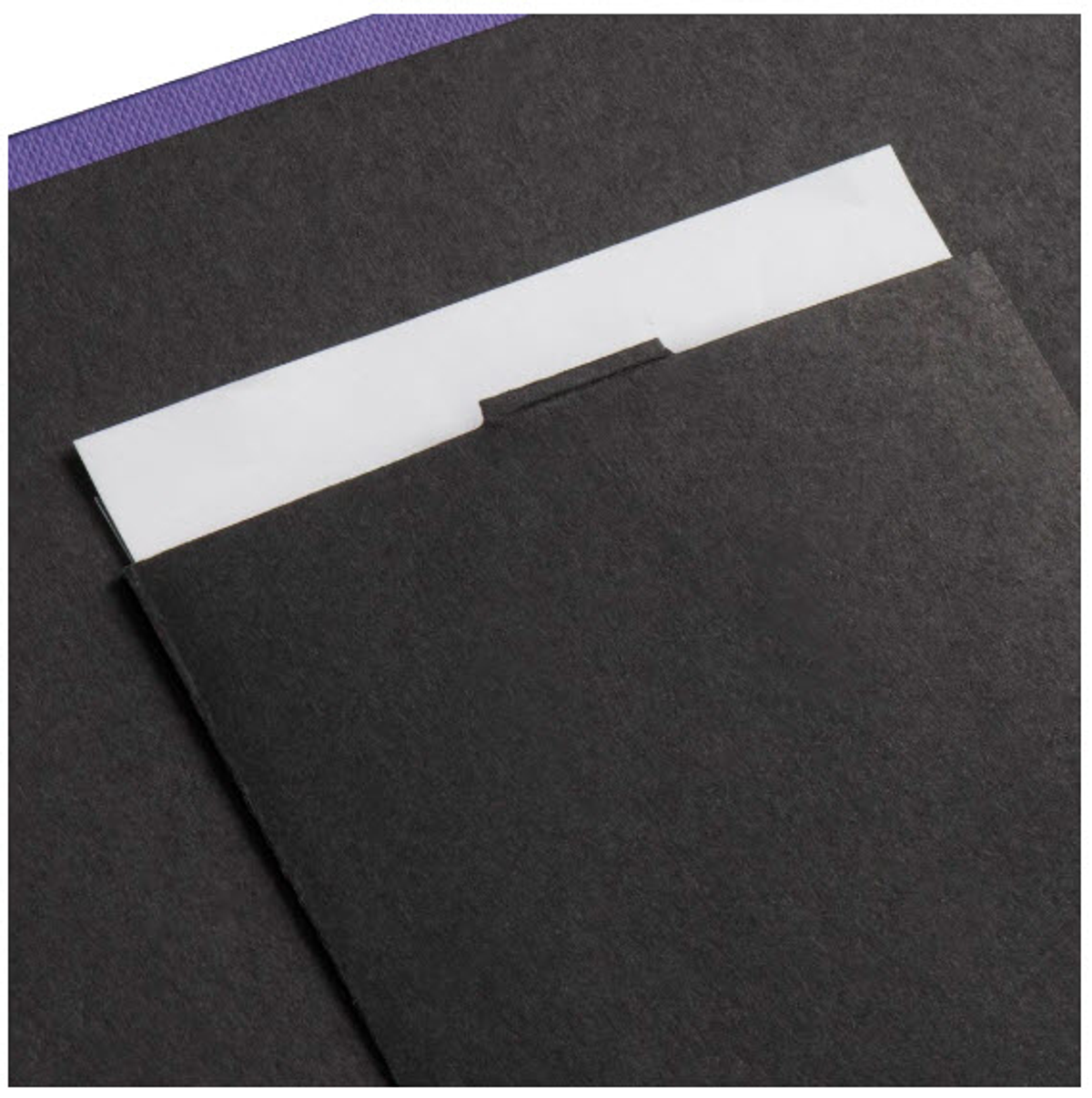 Czarny folder z białą etykietą jest otwarty.