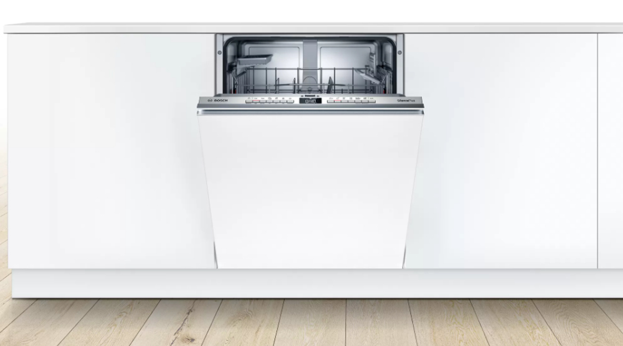 Een inbouwvaatwasser geïnstalleerd in een witte keuken, met de deur iets open.