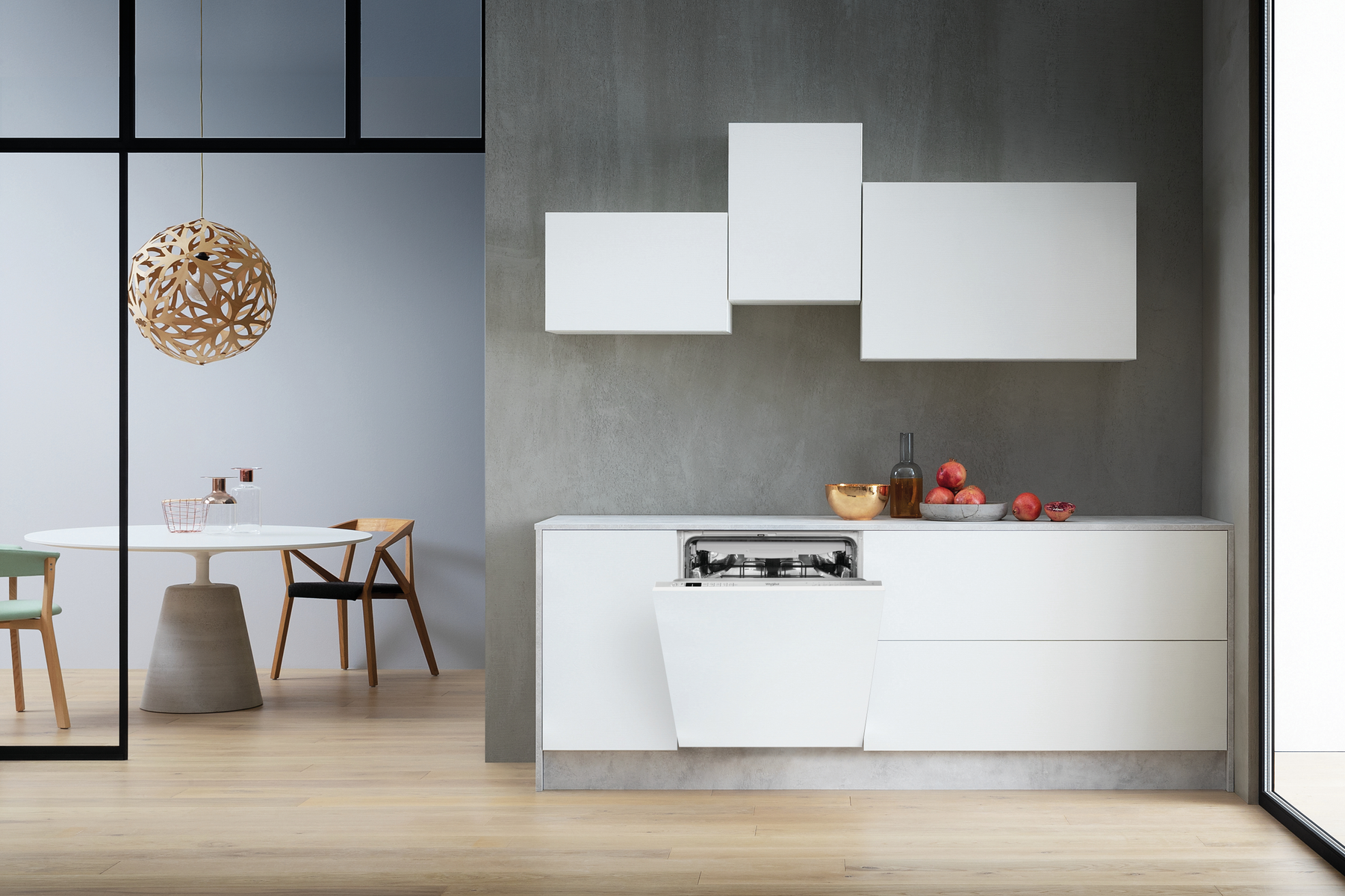 Modern white kitchen with open dishwasher, table, and decorative lighting.