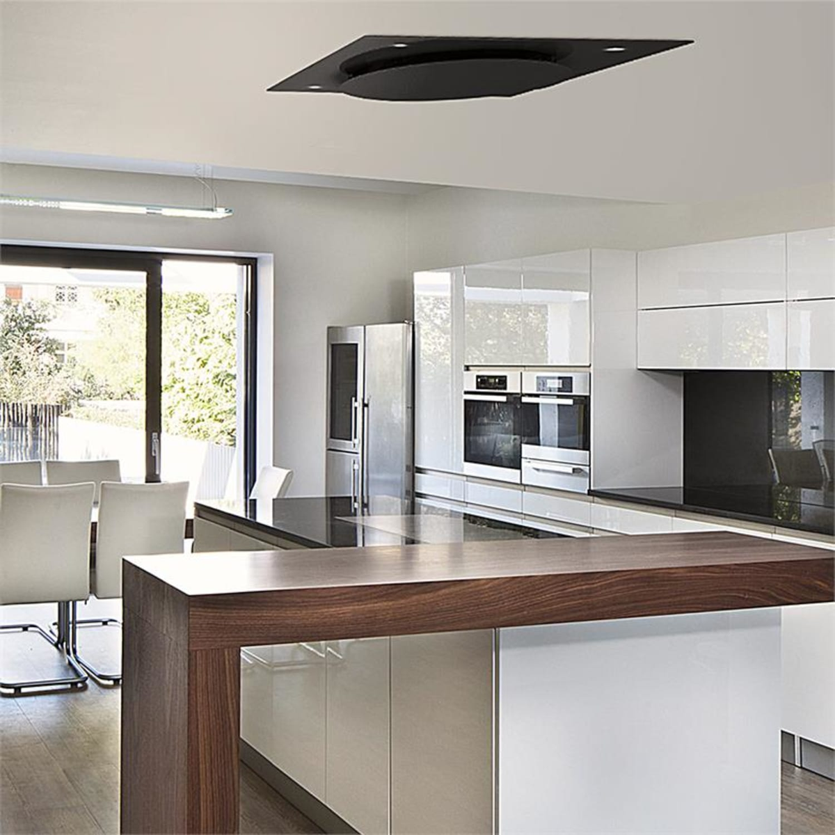 Cucina moderna con isola, mobili bianchi e illuminazione a soffitto integrata.