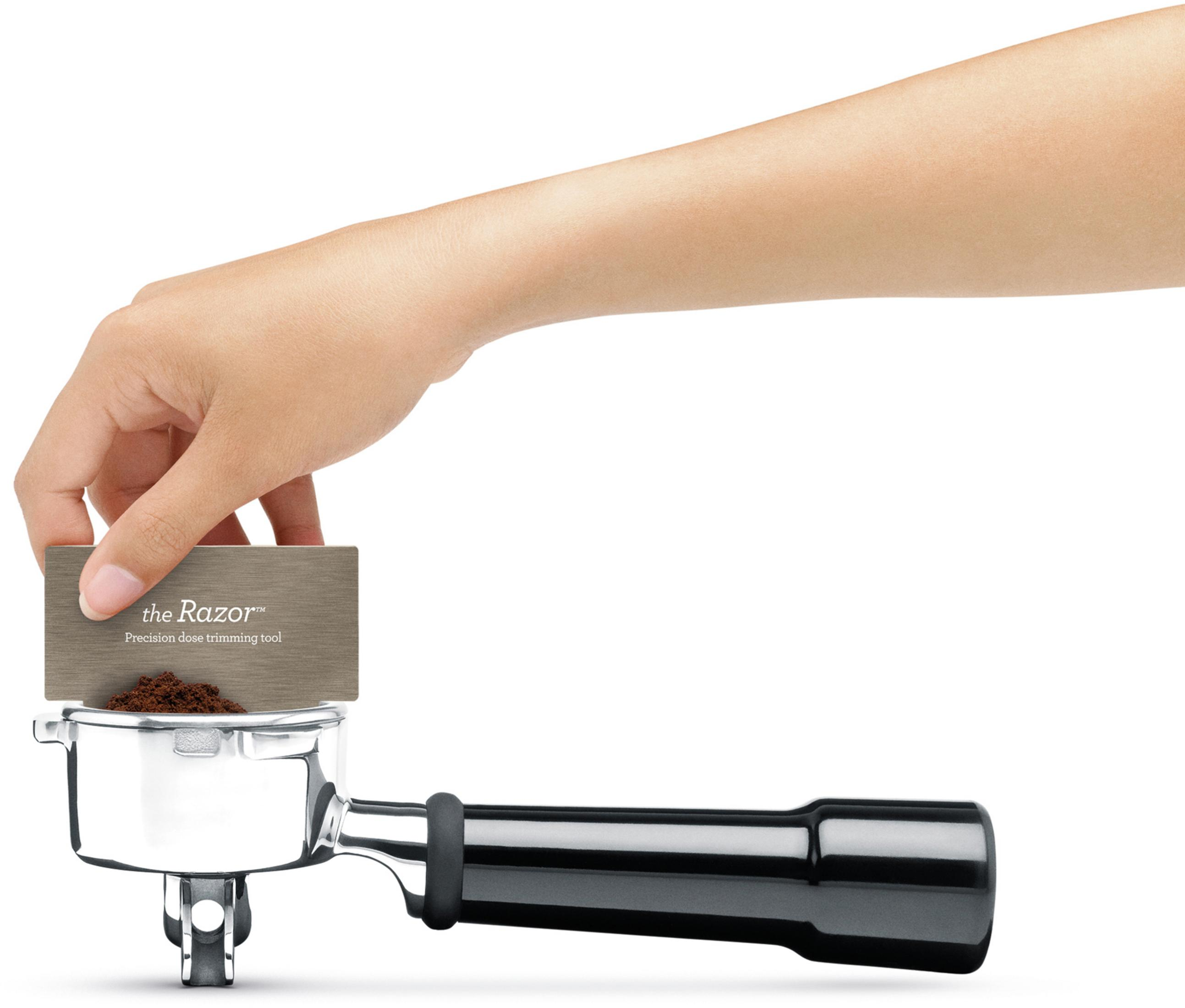 Ręka trzyma narzędzie nad kolbą z fusami kawy, widoczny tekst Razor.